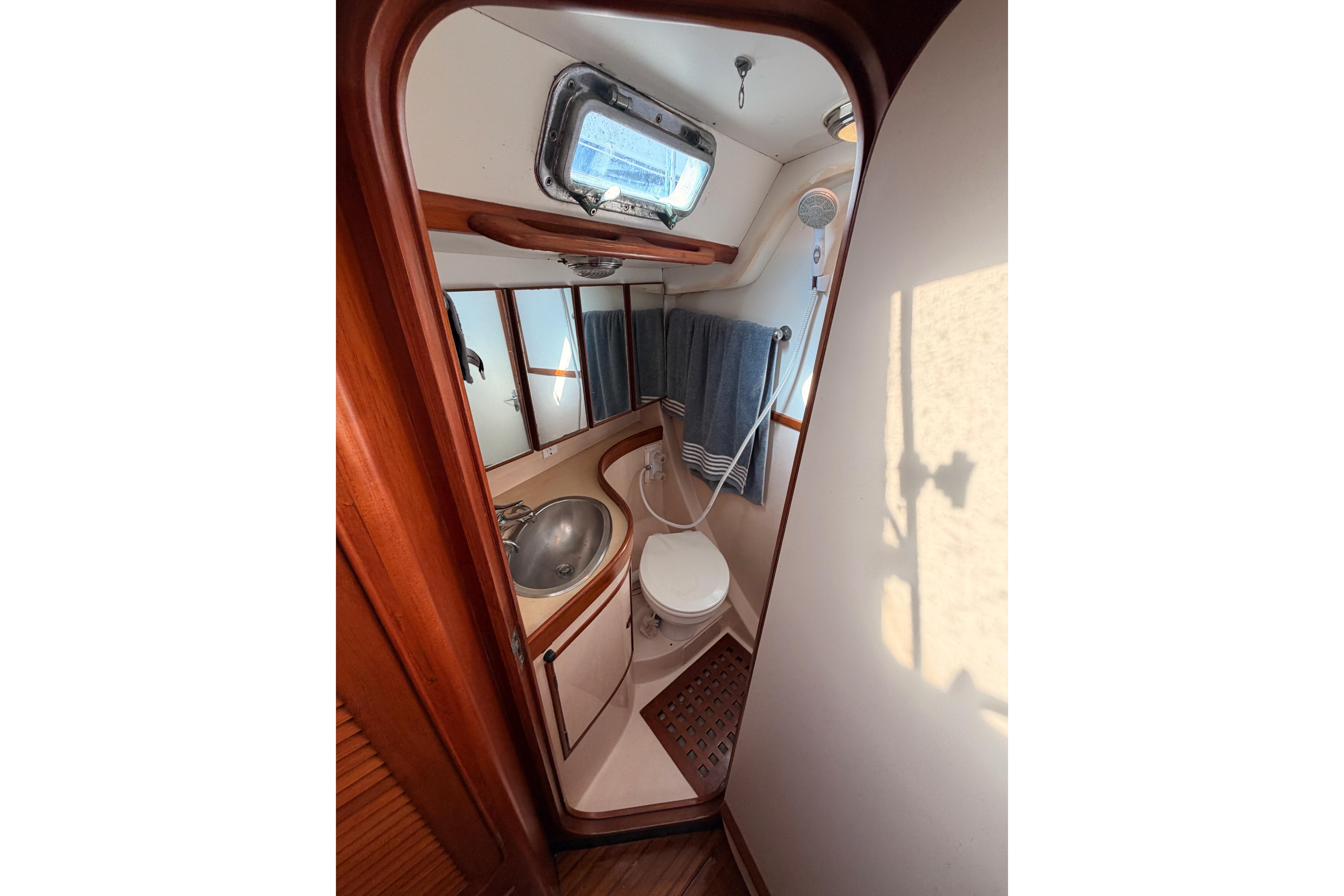 Bathroom interior of a 1991 Hylas 51 yacht, featuring sink, toilet, and shower.