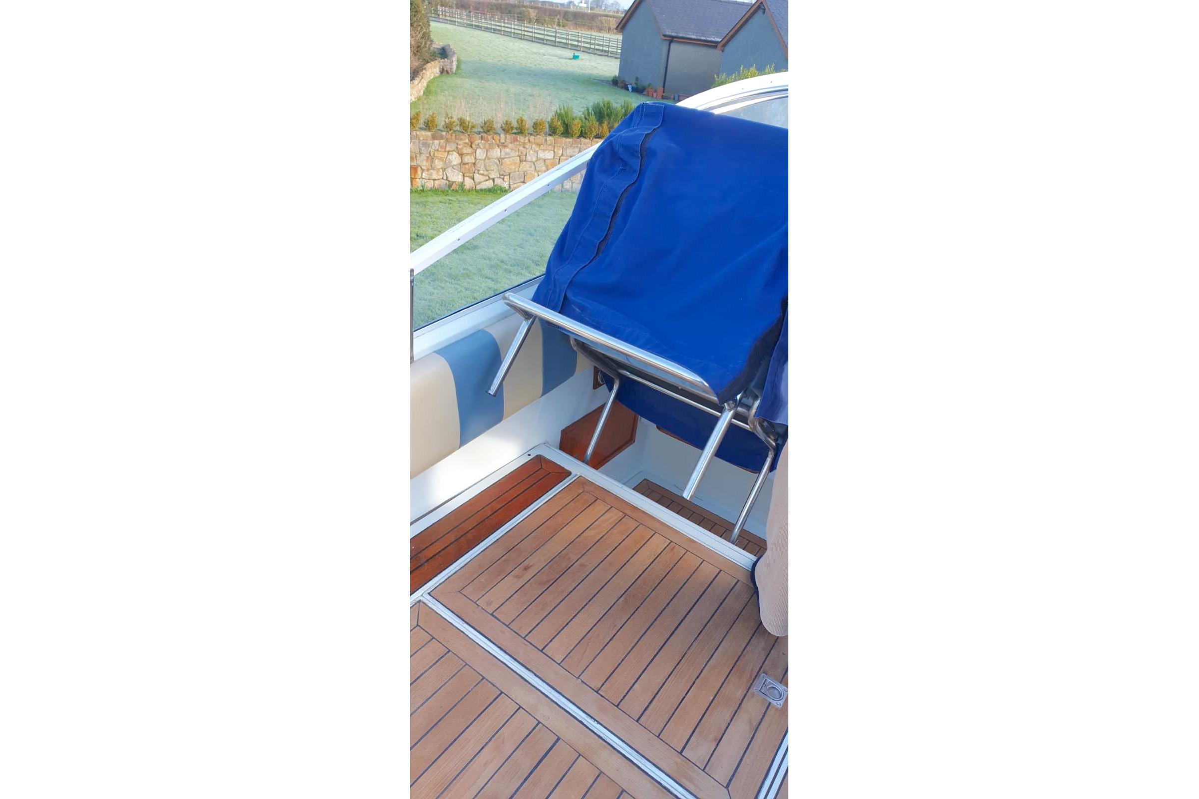 Deck of 1989 Fairey Spearfish MKIII boat with blue seat cover and wooden flooring.
