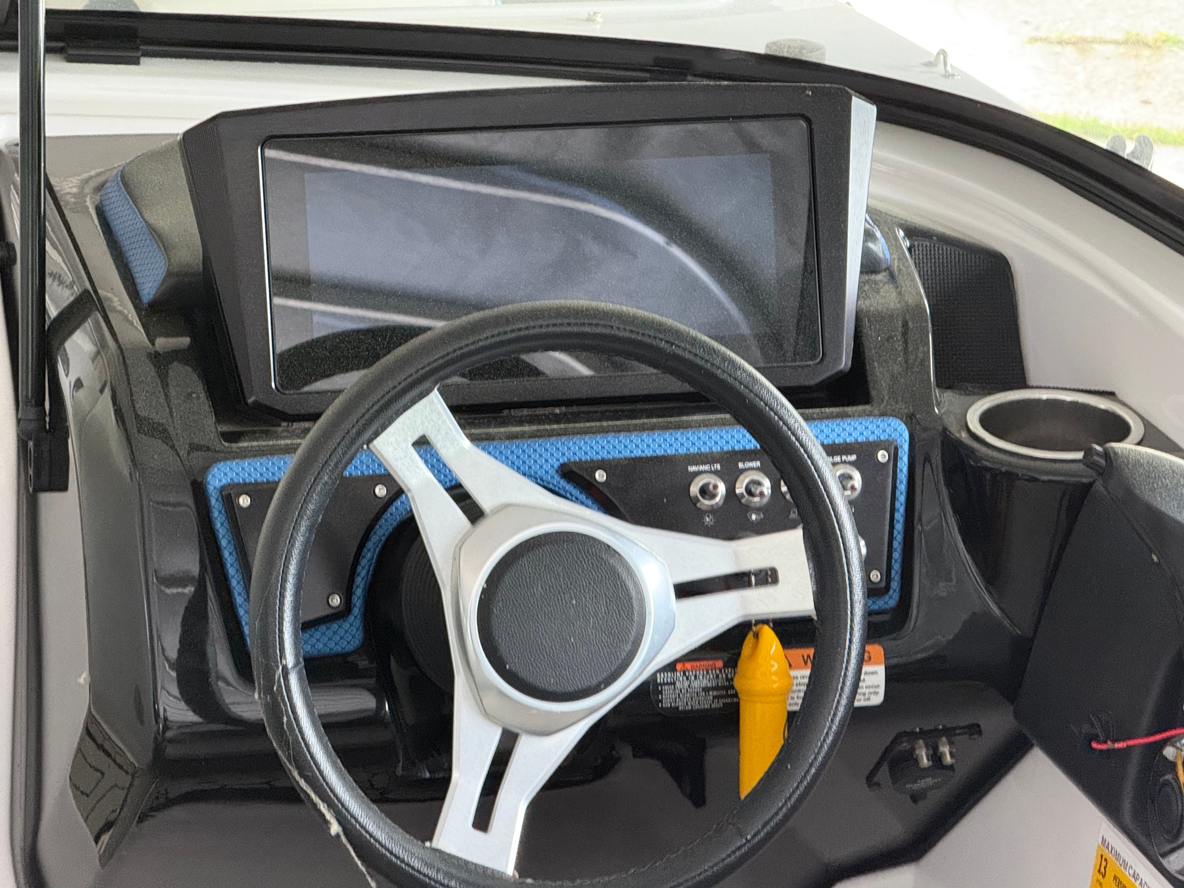 The image shows the helm of a 2018 Scarab 255 HOI boat with a large screen.
