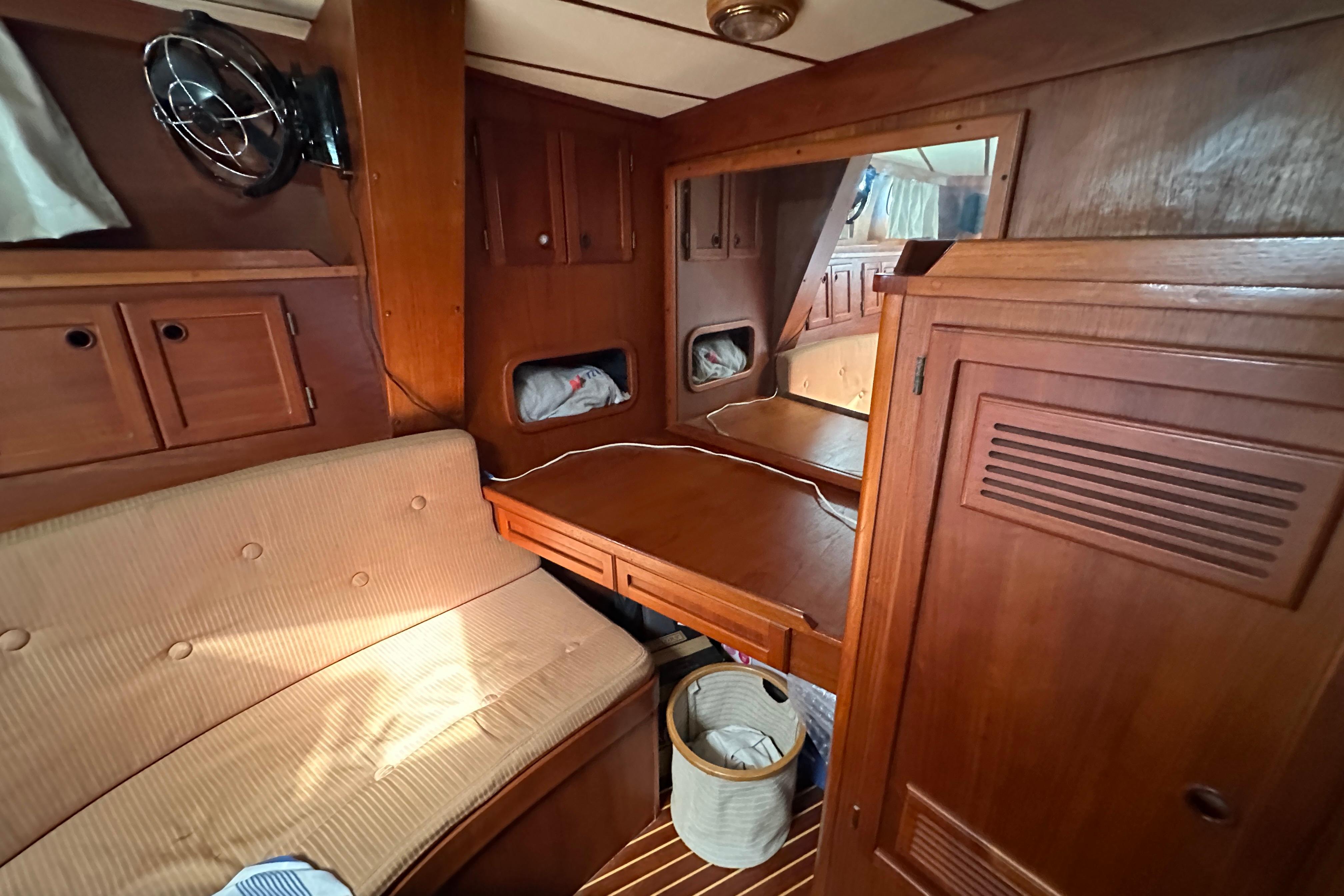 Cozy 1987 Nauticat 521 yacht interior with wooden cabinetry and seating area.