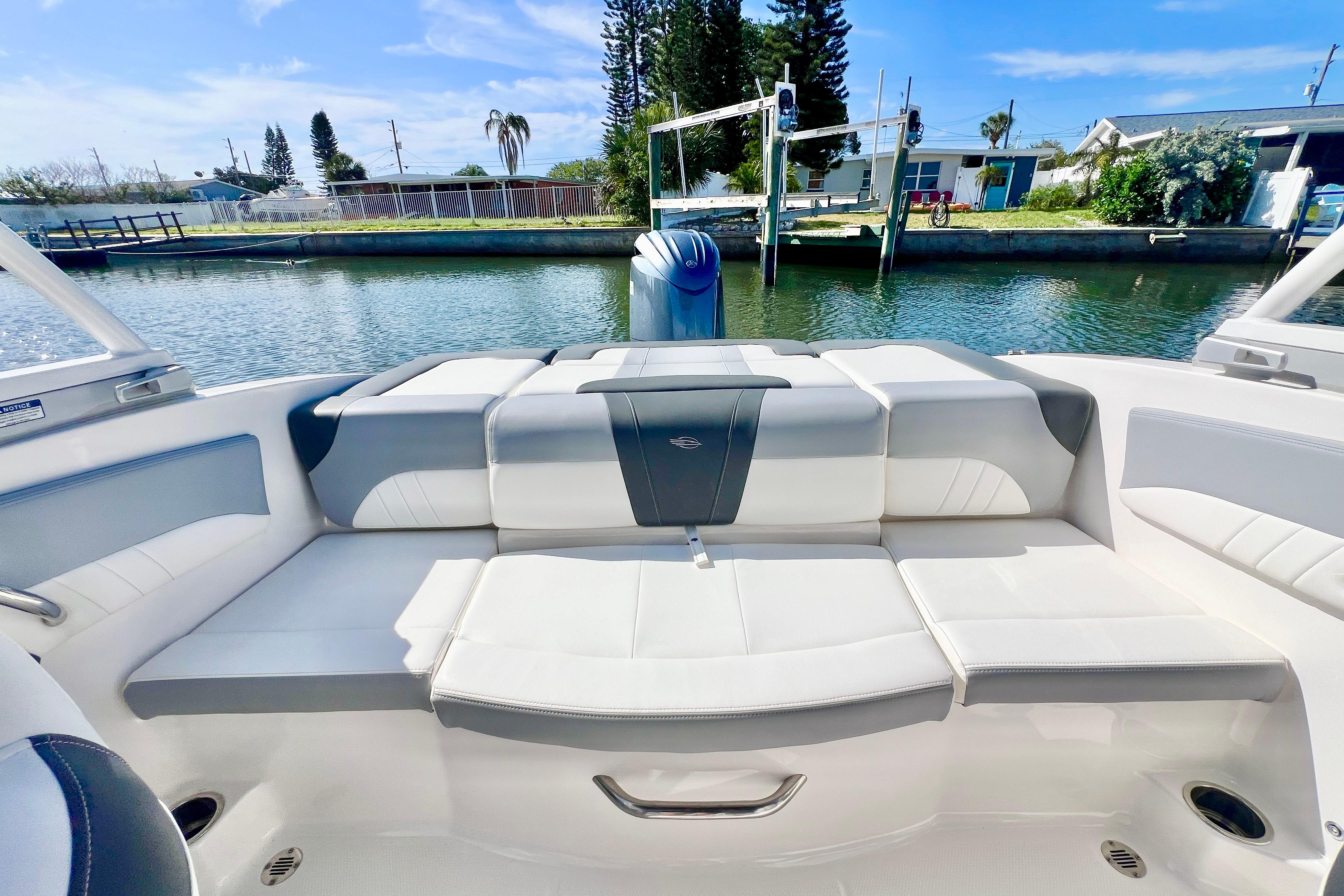 2023 Chaparral 21 SSi OB boat interior with cushioned seating by the water.