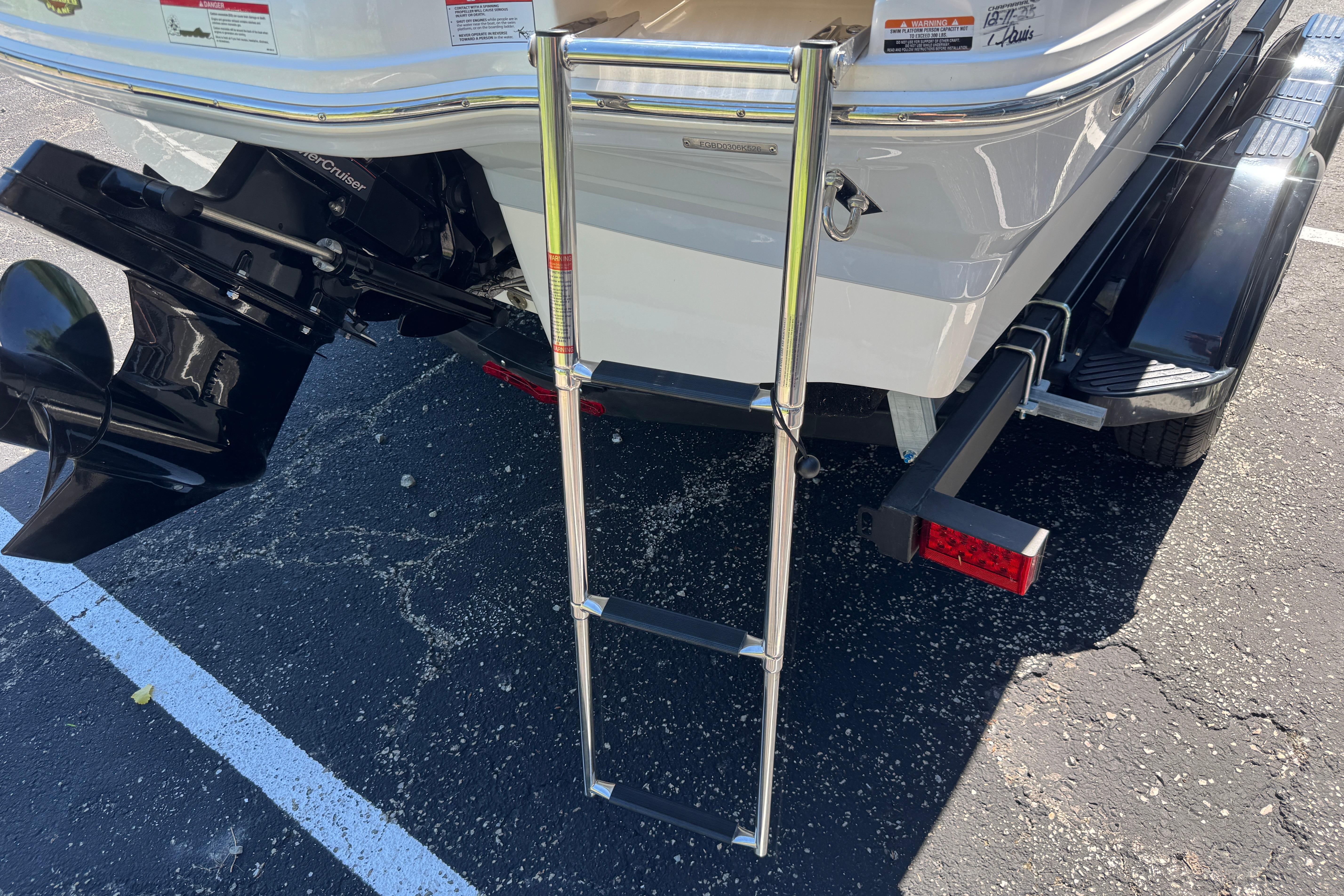 Rear view of 2026 Chaparral 21 SSi boat with ladder and trailer.