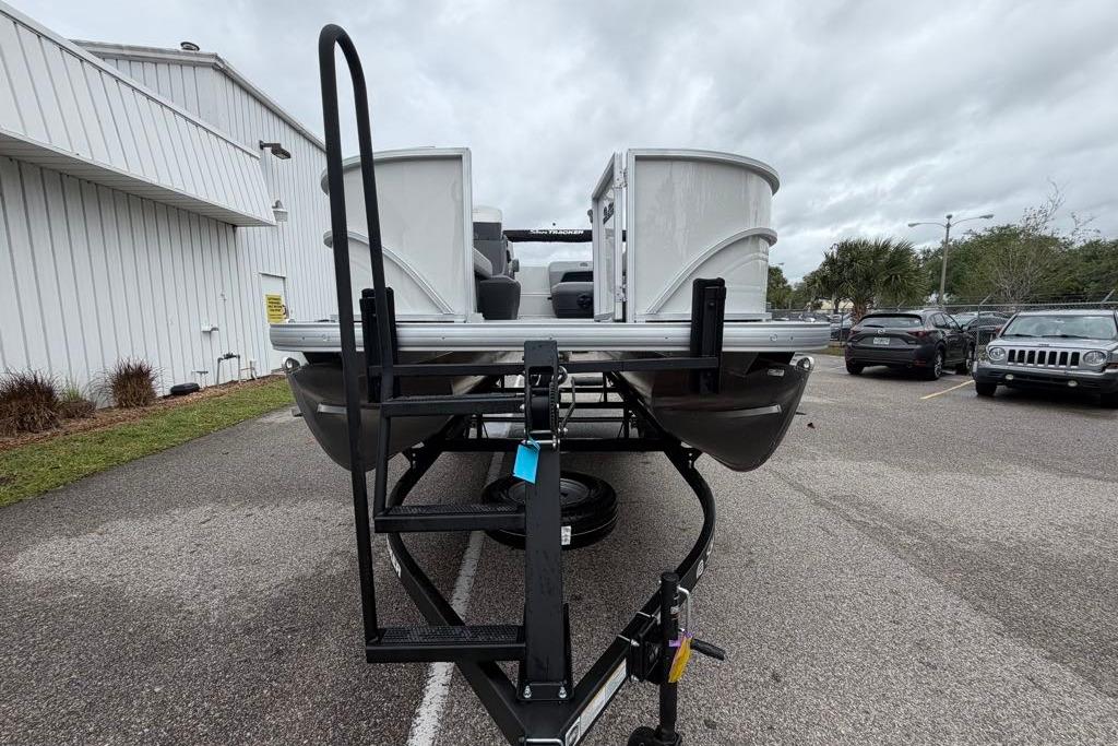 2026 Sun Tracker Party Barge 16 DLX pontoon boat on trailer, parked outdoors.