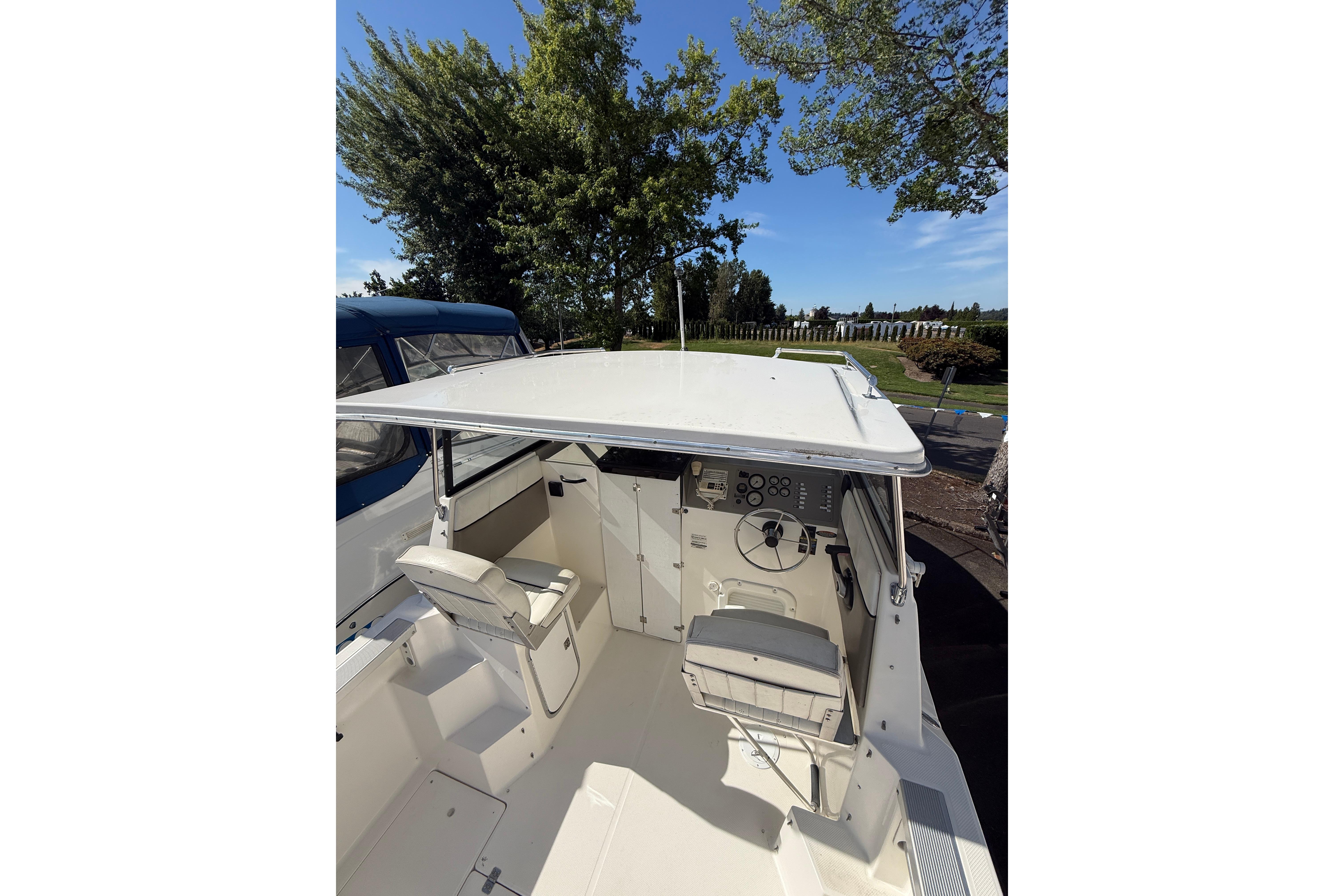 1997 Bayliner 2452 Ciera Express boat interior with helm and seating under canopy.