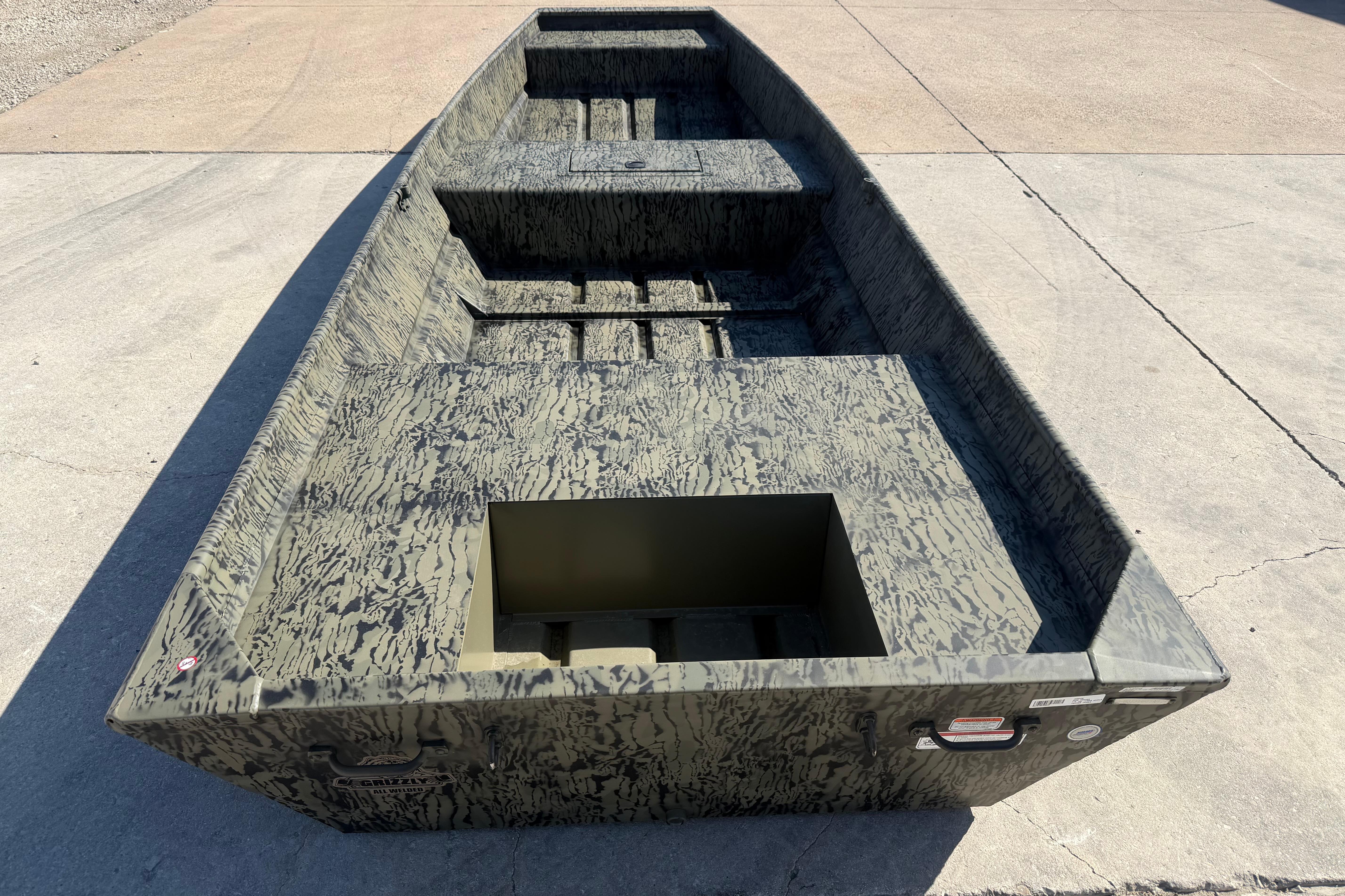 2026 Tracker Grizzly 15 Jon boat with camouflage design on concrete surface.