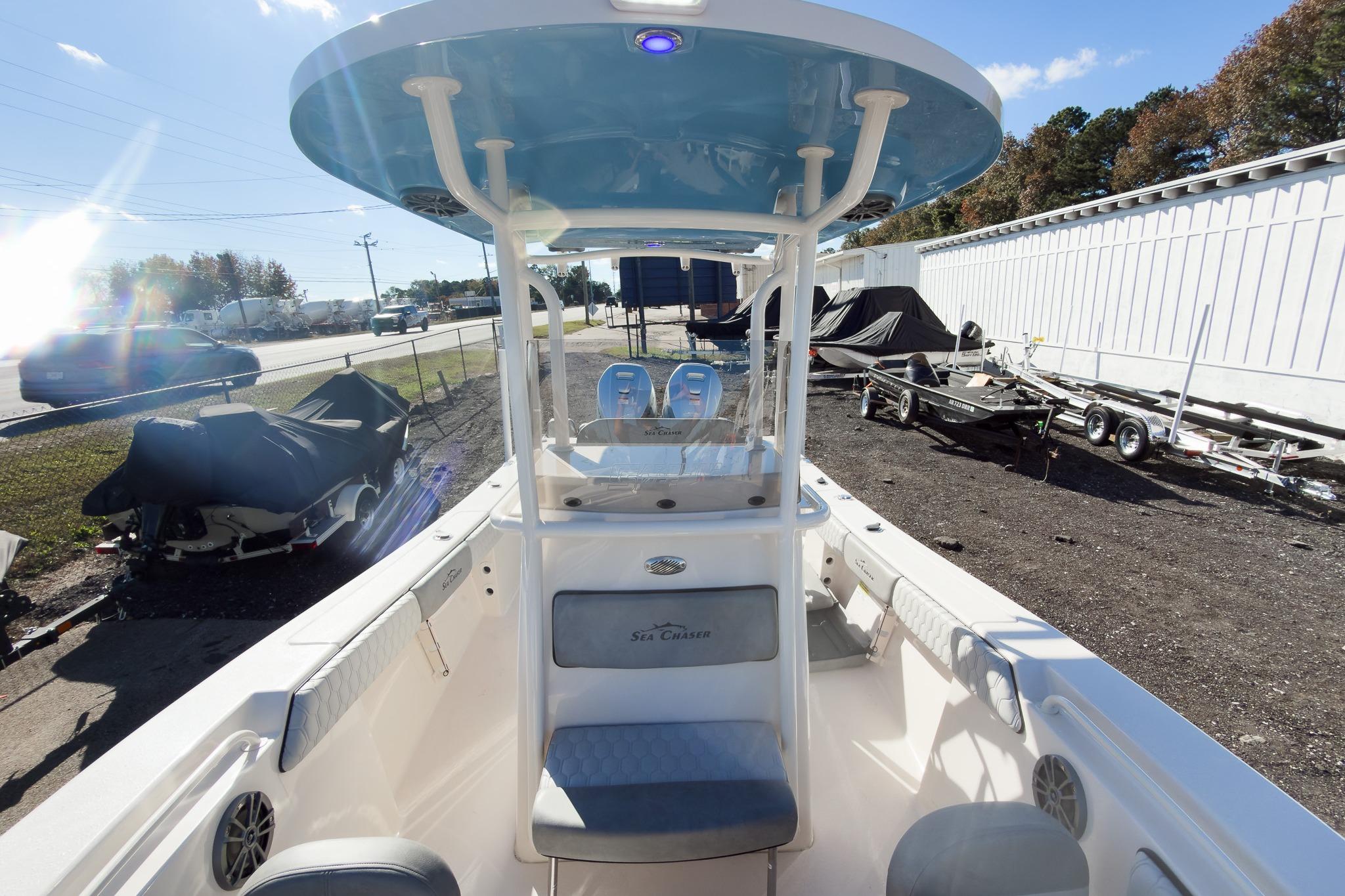 2026 Sea Chaser 24 HFC DE boat interior with seating and console, parked outdoors.