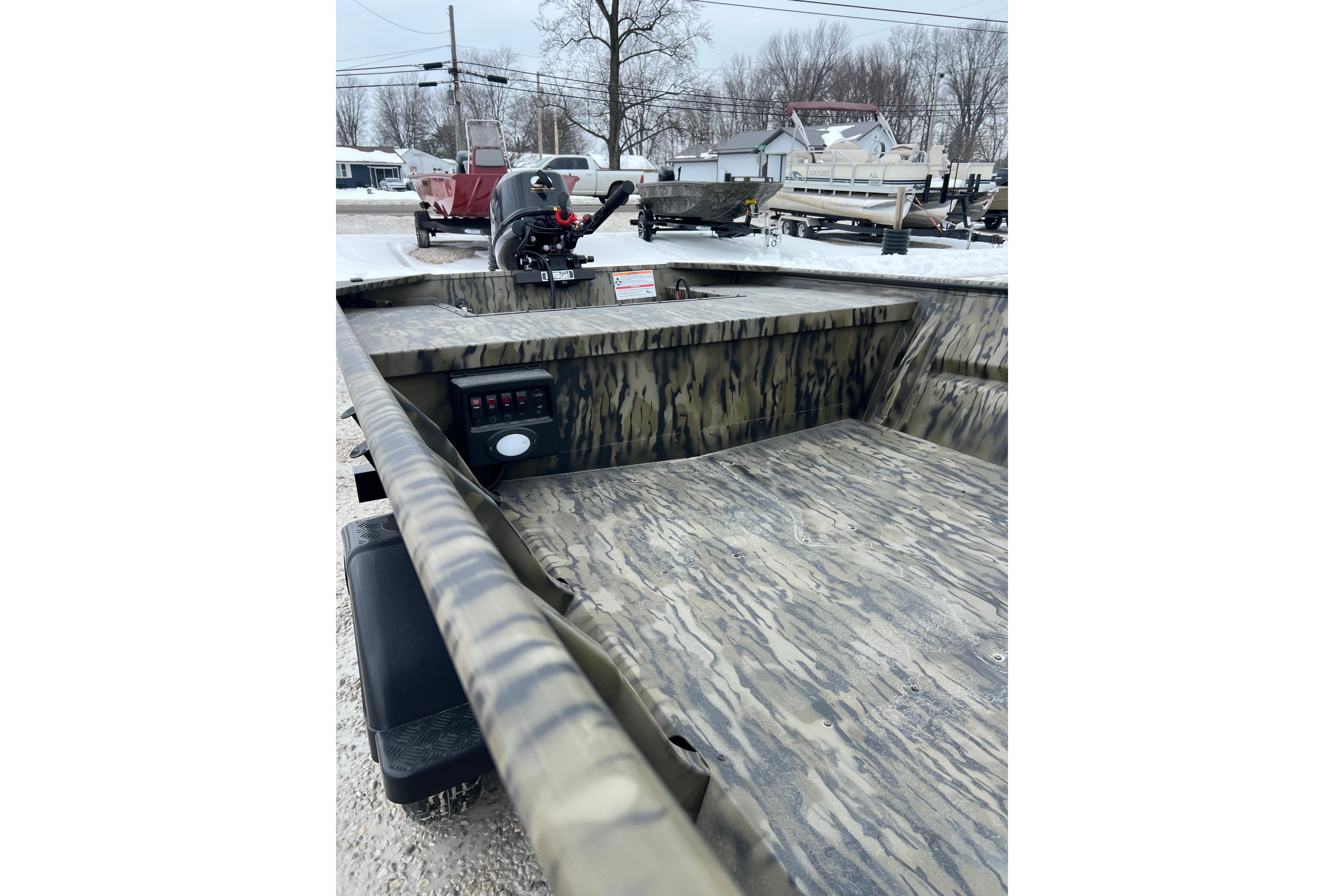 2026 SeaArk 1648 MV Special boat with camouflage interior, parked on snowy ground.