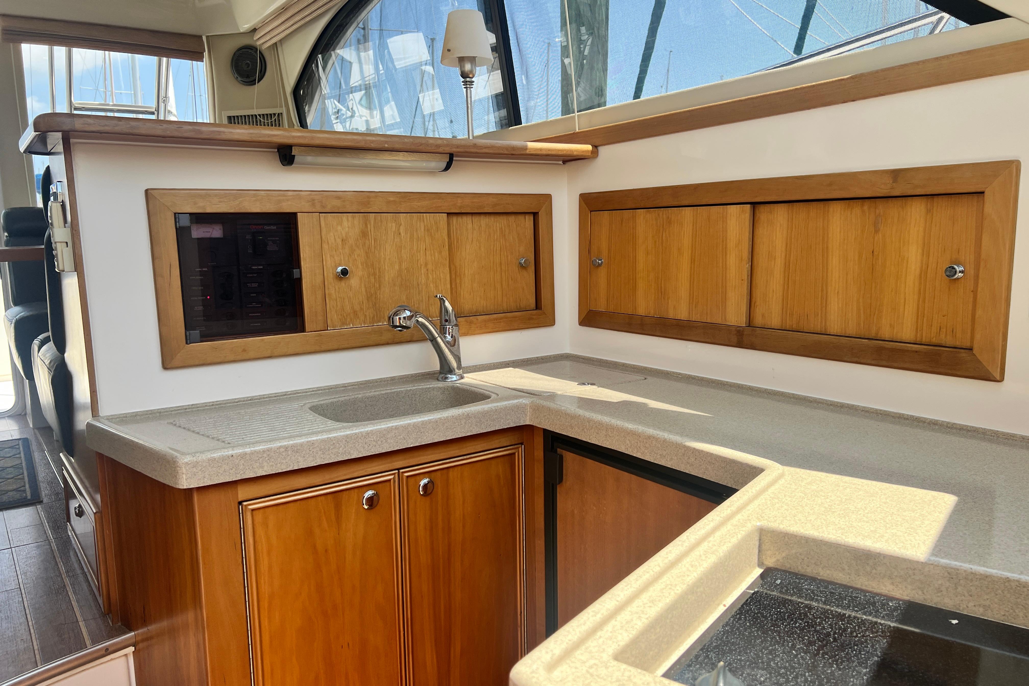 2007 Riviera 33 Flybridge yacht interior kitchen with wooden cabinets and sink.