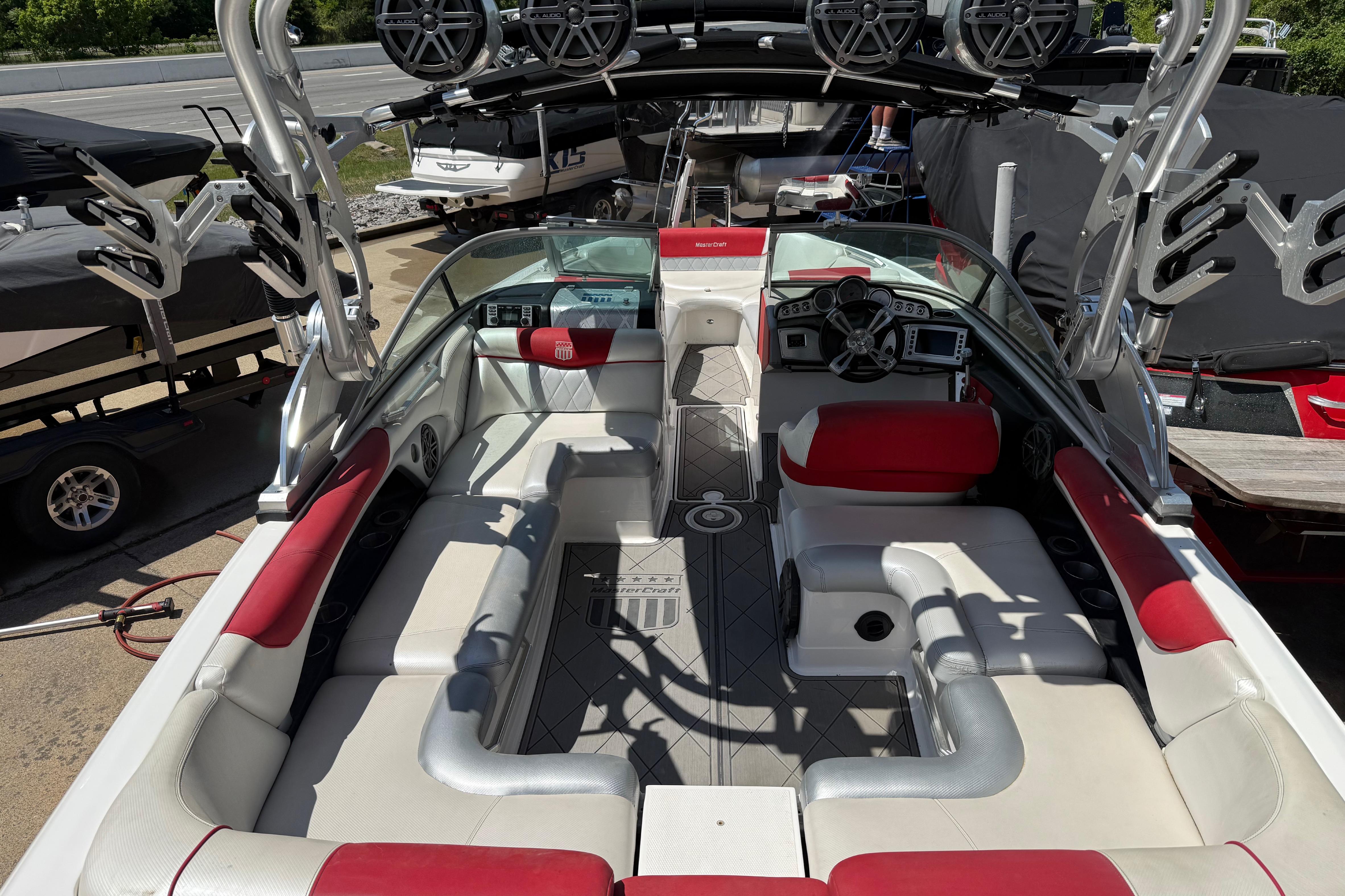 2013 MasterCraft X-45 boat interior with red and white seating, speakers, and control panel.
