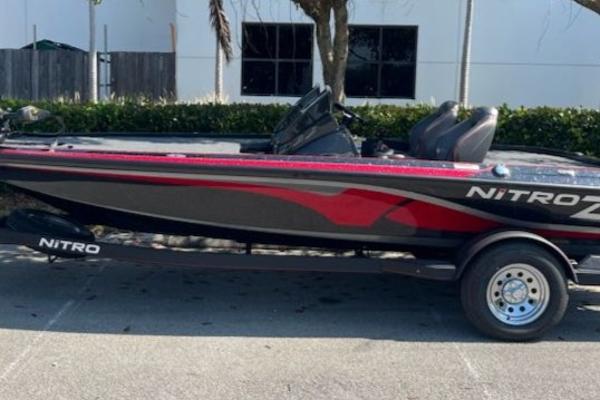 2024 Nitro Z19 boat with red and black design parked on a trailer.