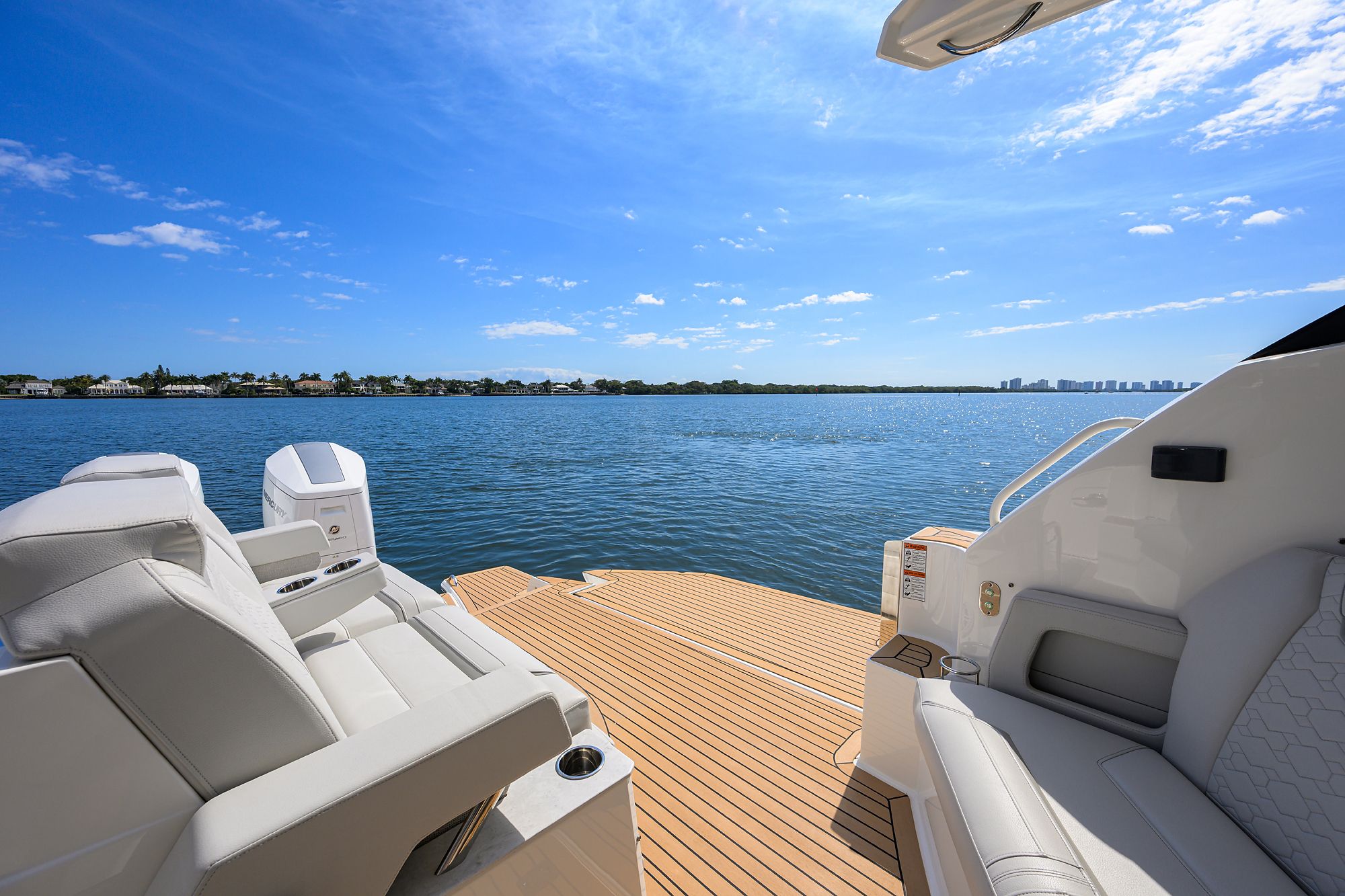 Luxurious boat with comfortable seating on calm water under a blue sky.