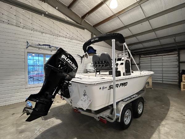 2025 Sea Pro 210 Bay boat with Suzuki engine in a garage.