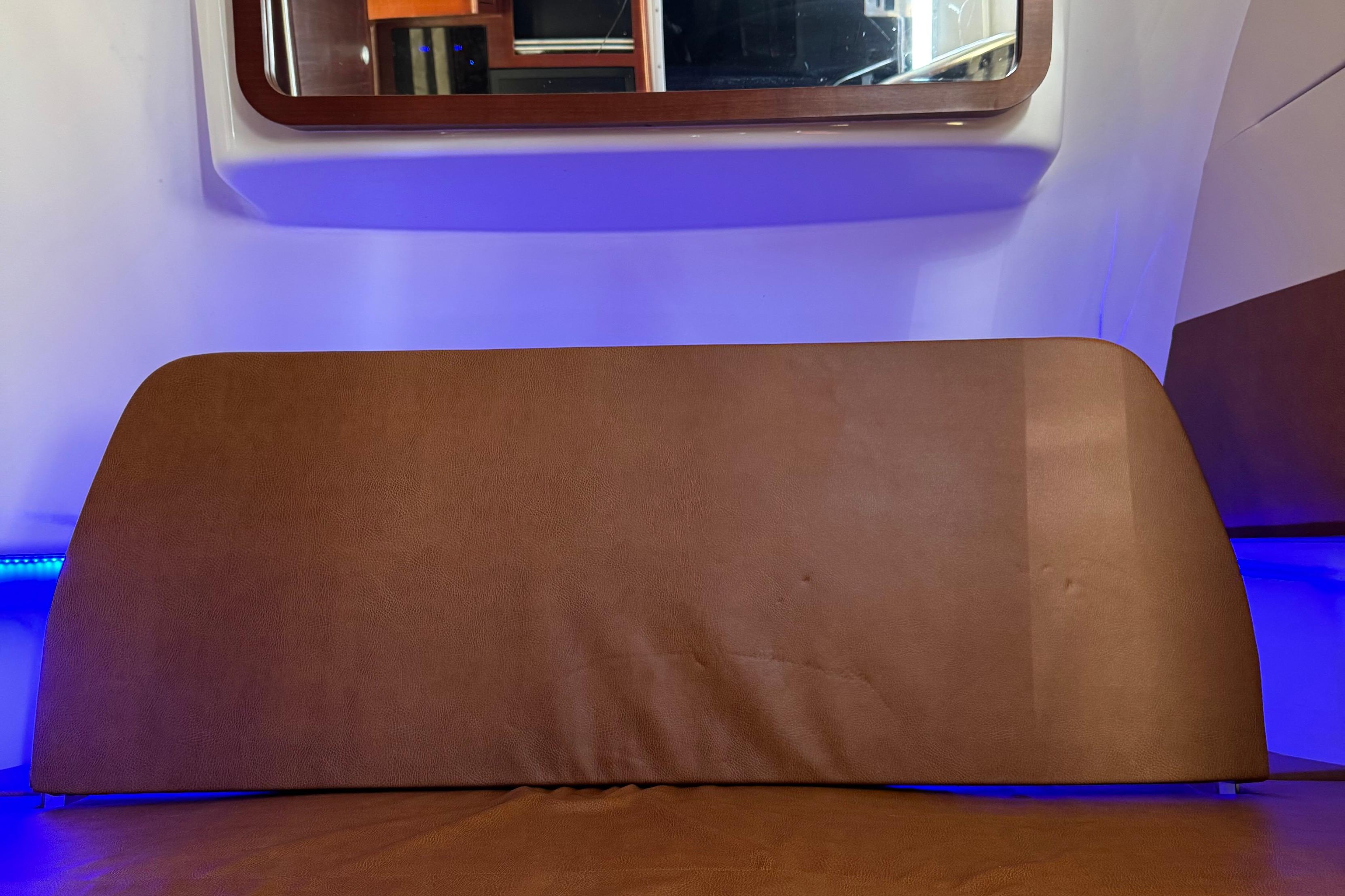 Interior of 2016 Edgewater 370CC boat with brown seating and blue ambient lighting.