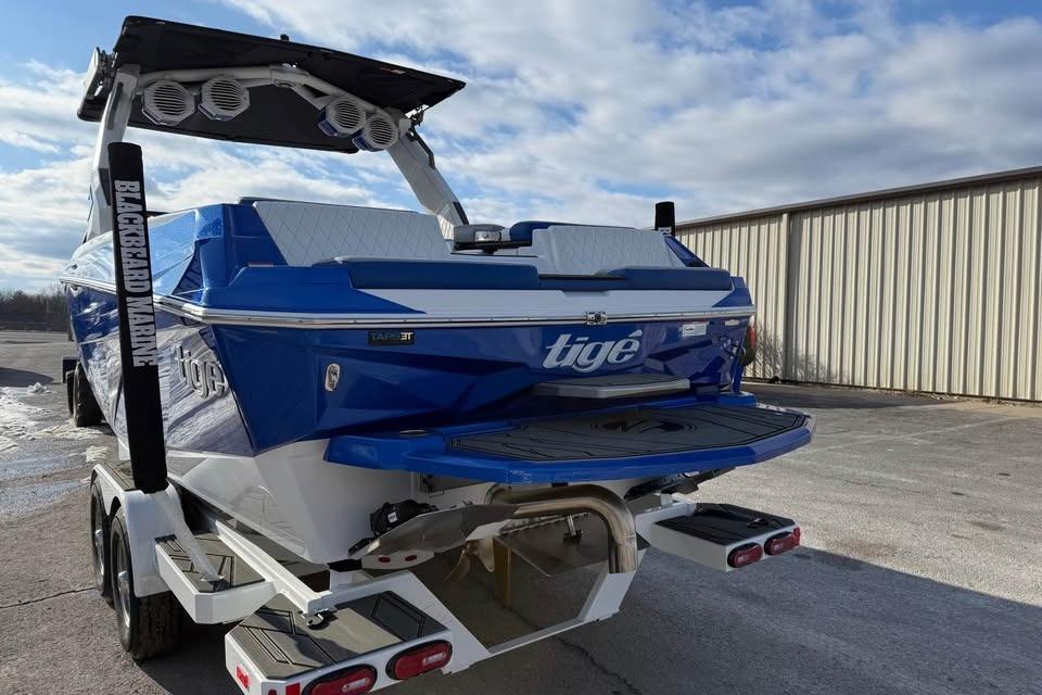 2026 Tigé Z3 boat in blue, parked on a trailer under a cloudy sky.