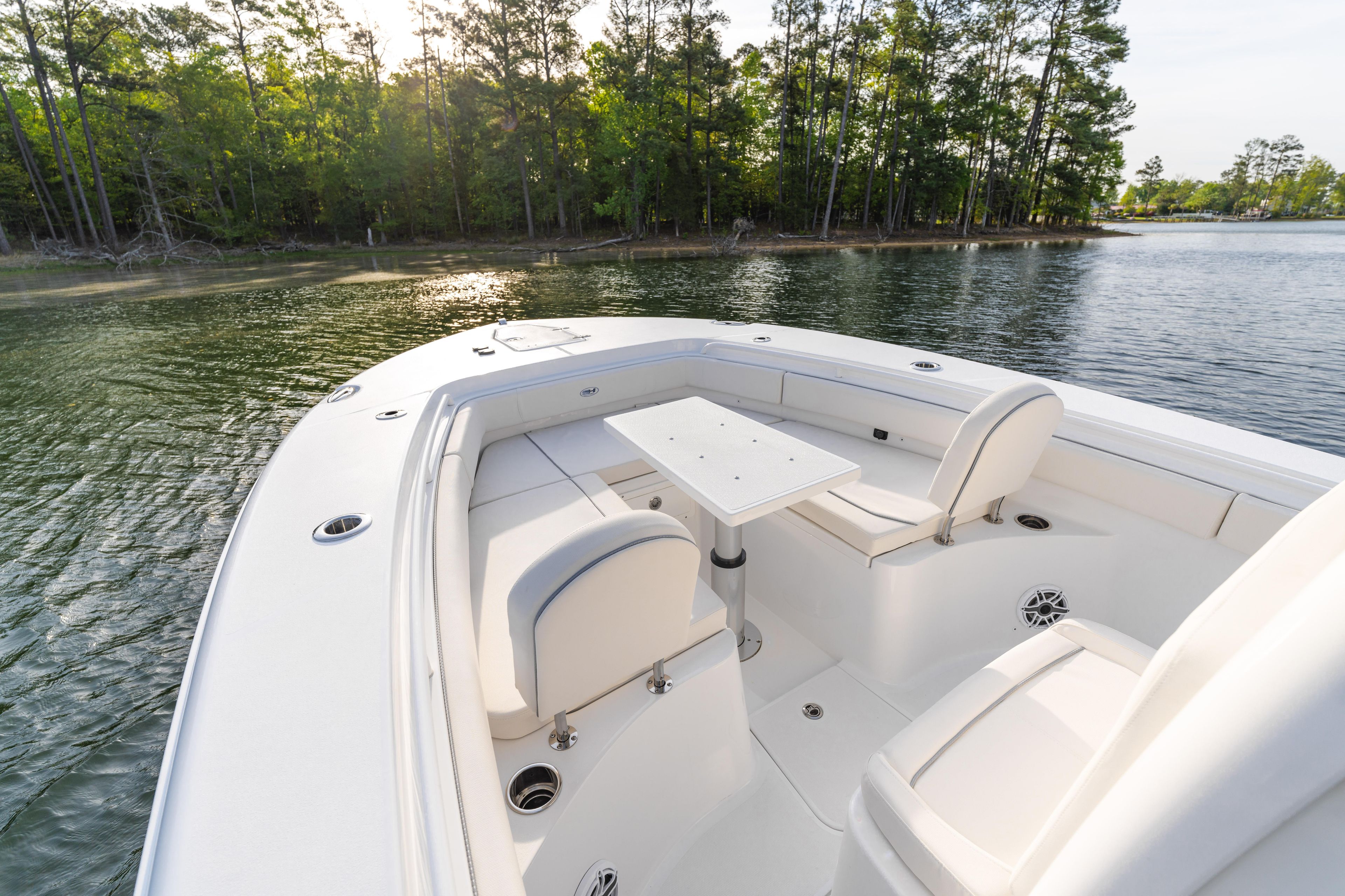 2027 Sea Hunt Ultra 275 SE boat interior with seating and table on calm water.