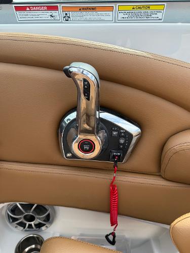 2025 Crownline 290 SS throttle control with beige leather interior and safety warnings.