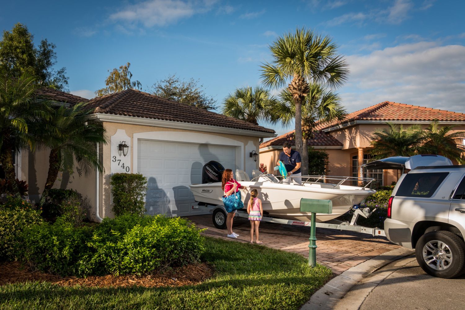 A family prepares to load a Boston Whaler 160 Super Sport boat onto a trailer.