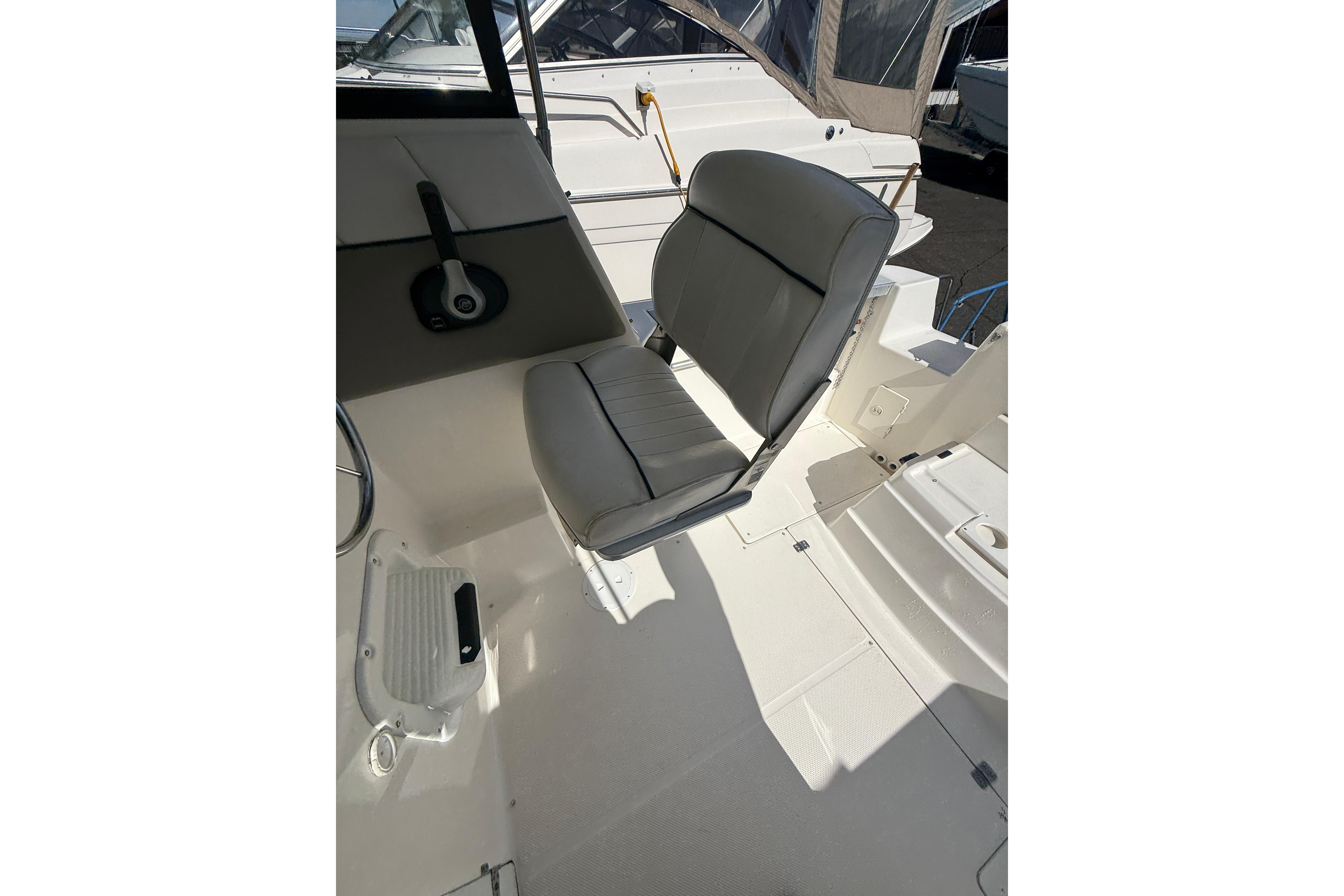 1997 Bayliner 2452 Ciera Express boat interior with gray captain's chair and control panel.