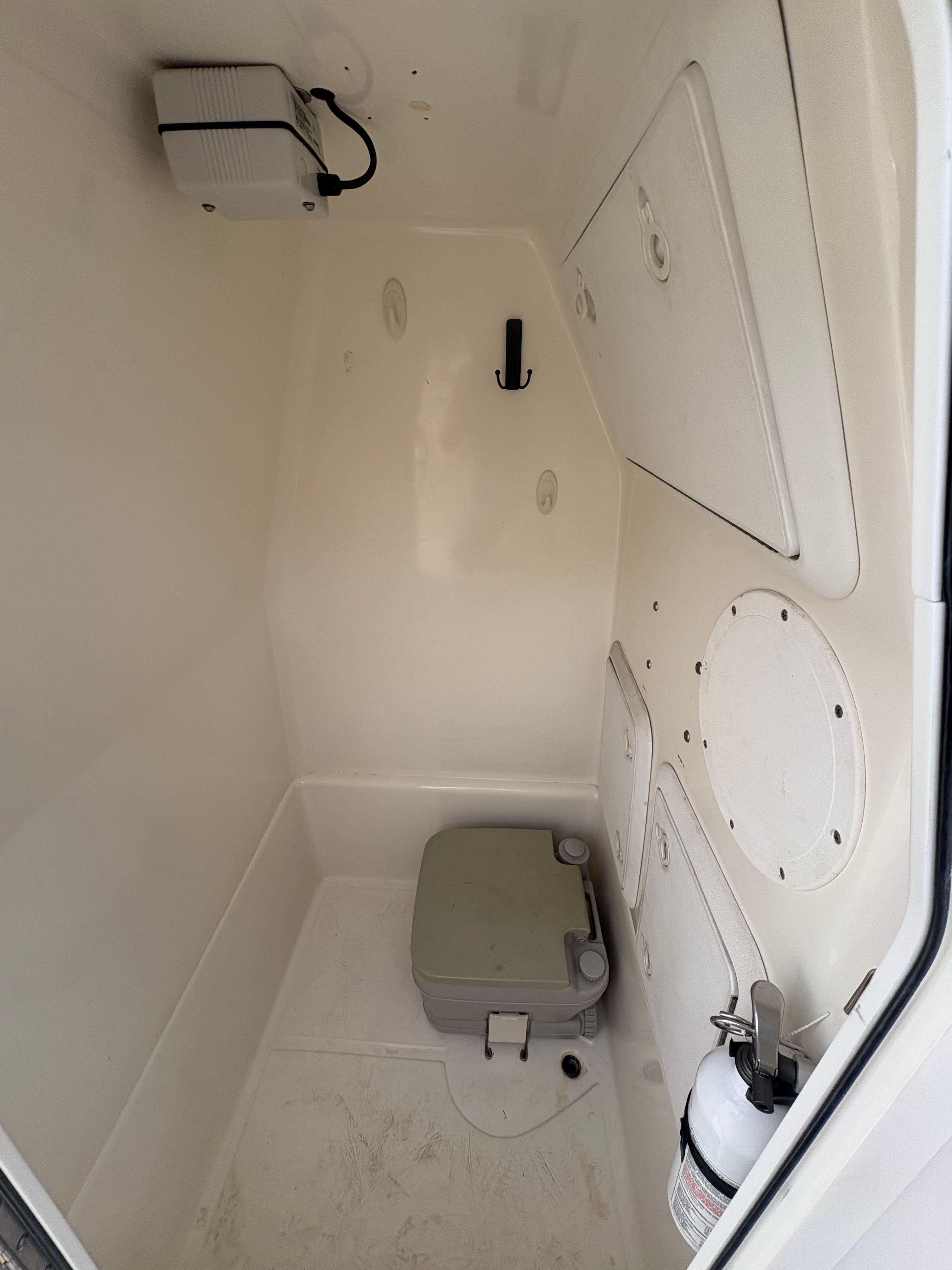 Interior of a 2008 Edgewater 228CC boat with portable toilet.