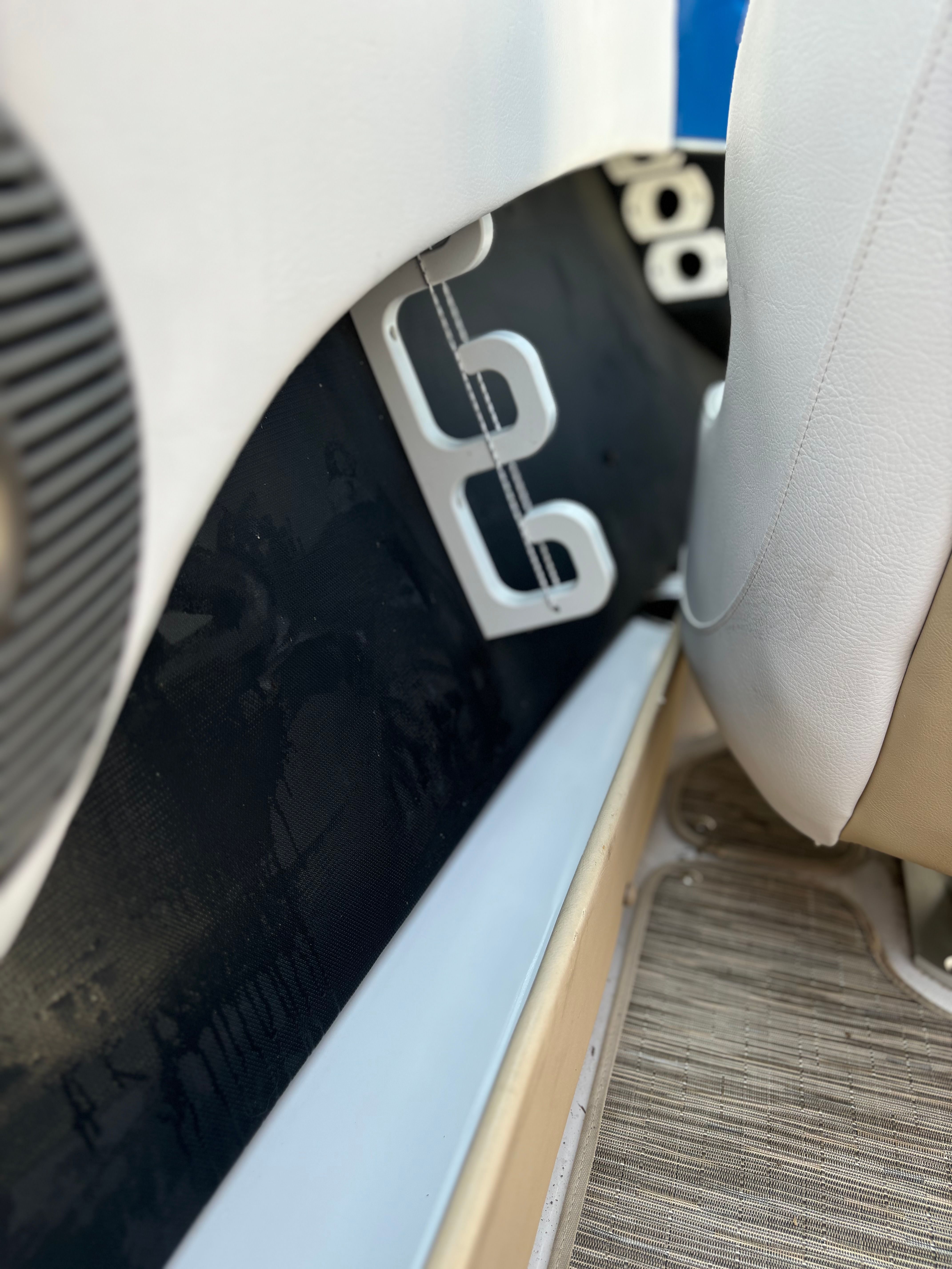 Close-up of a boat's interior with white seats and speakers.