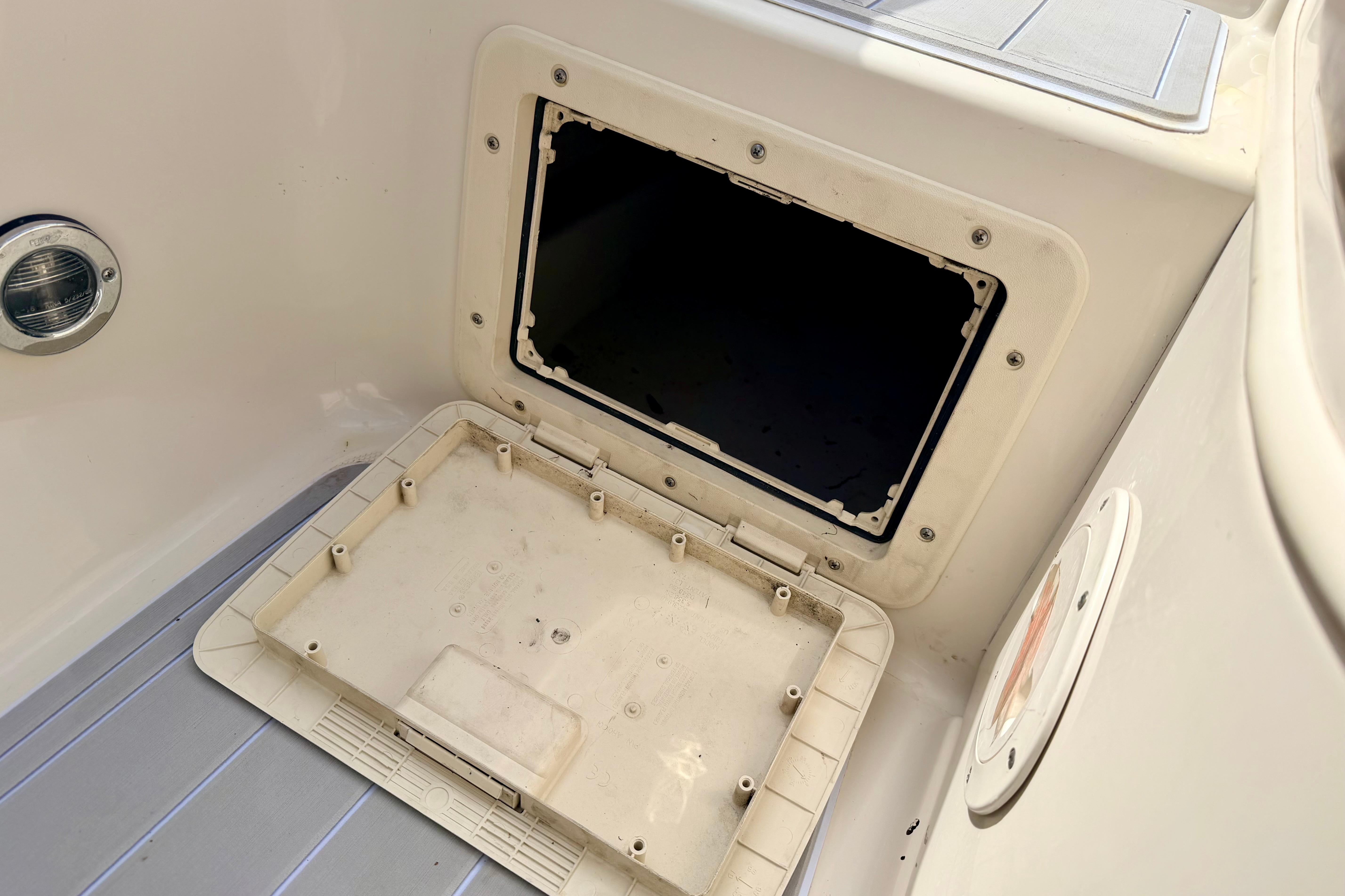 Open storage compartment on a 2003 Sea Ray 200 Sundeck boat interior.