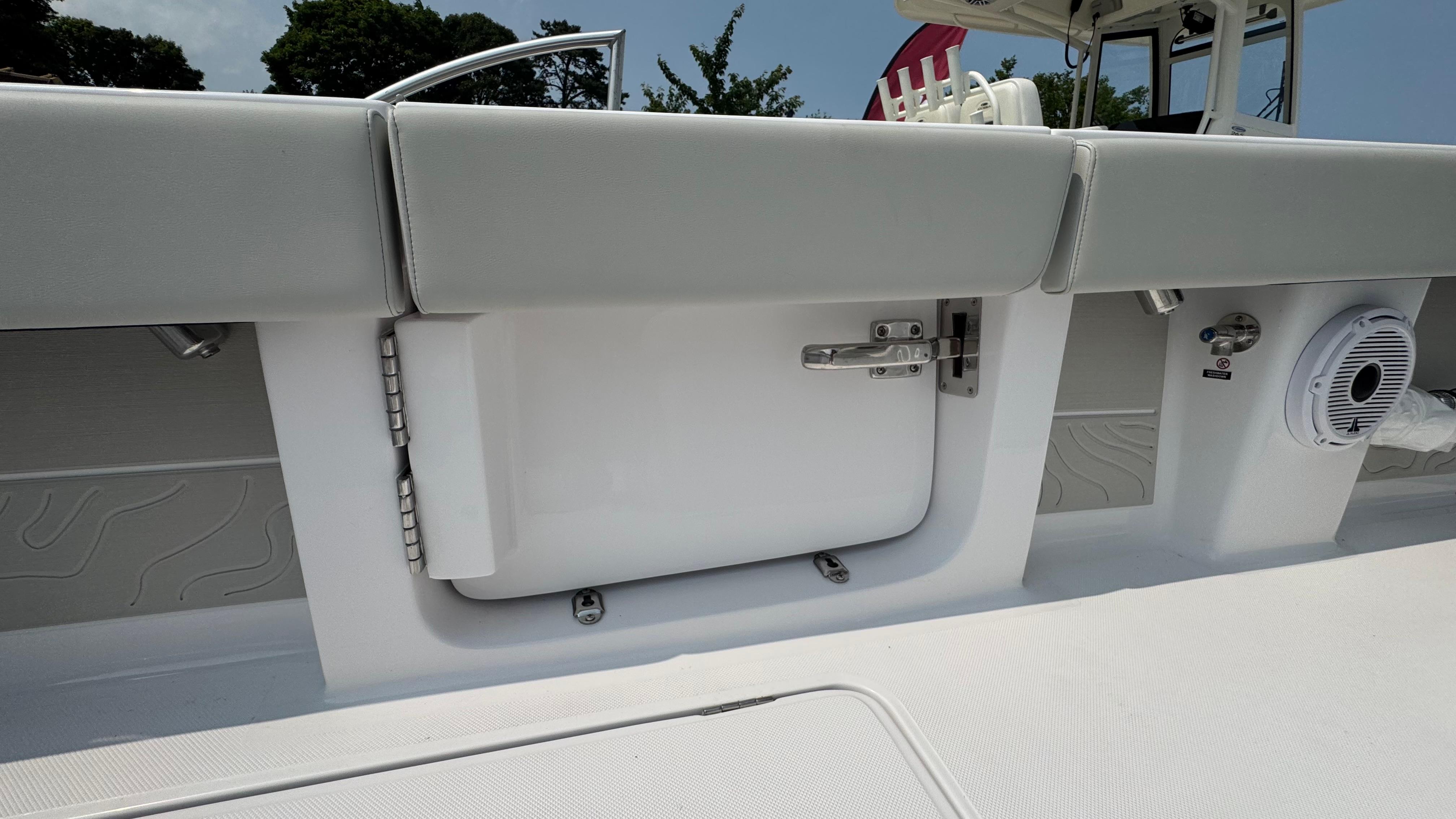 Interior view of a 2026 Jupiter 32 boat, featuring a storage compartment and speaker.