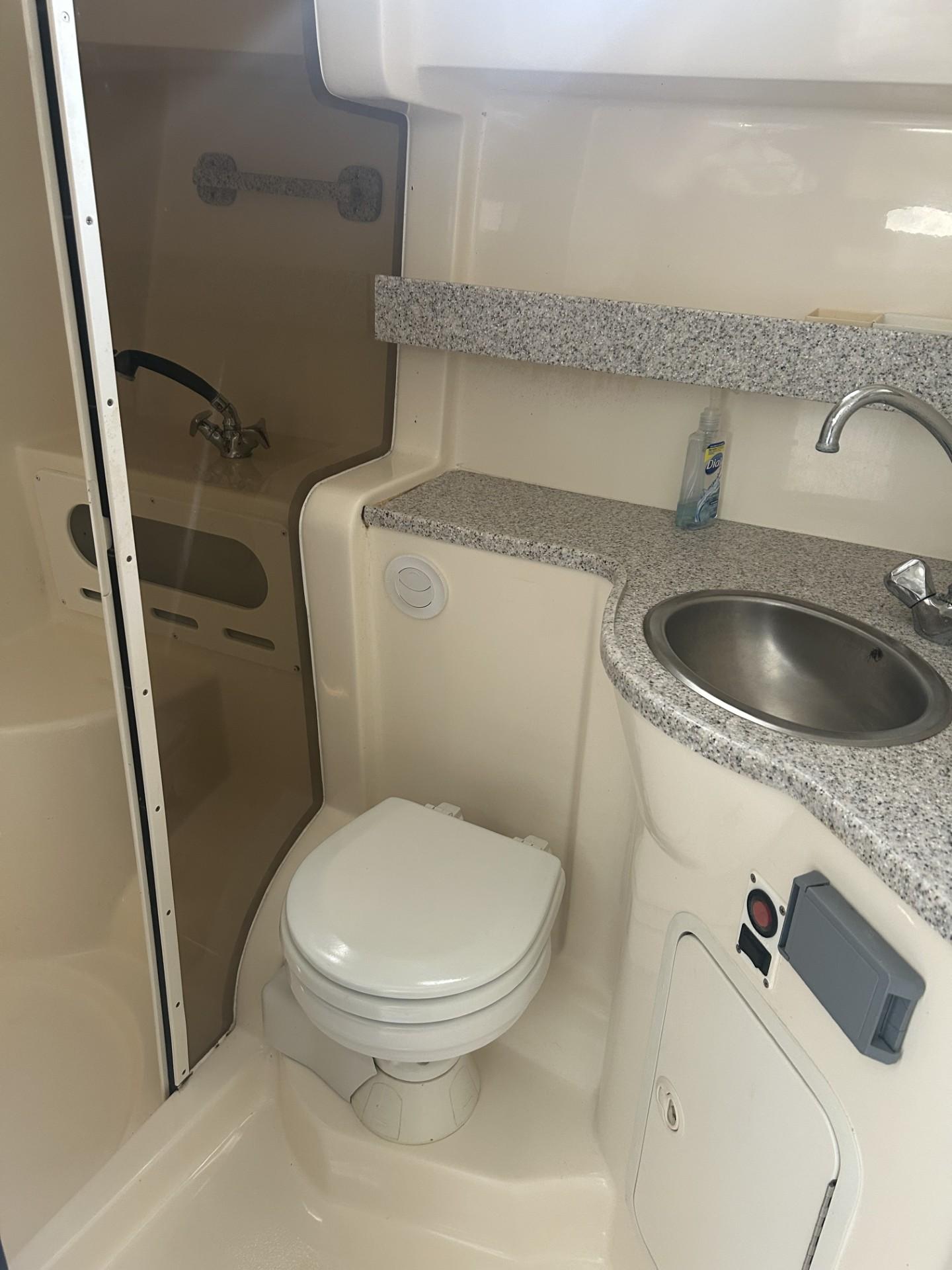 2002 Rinker 342 Fiesta Vee boat bathroom with toilet, sink, and shower.