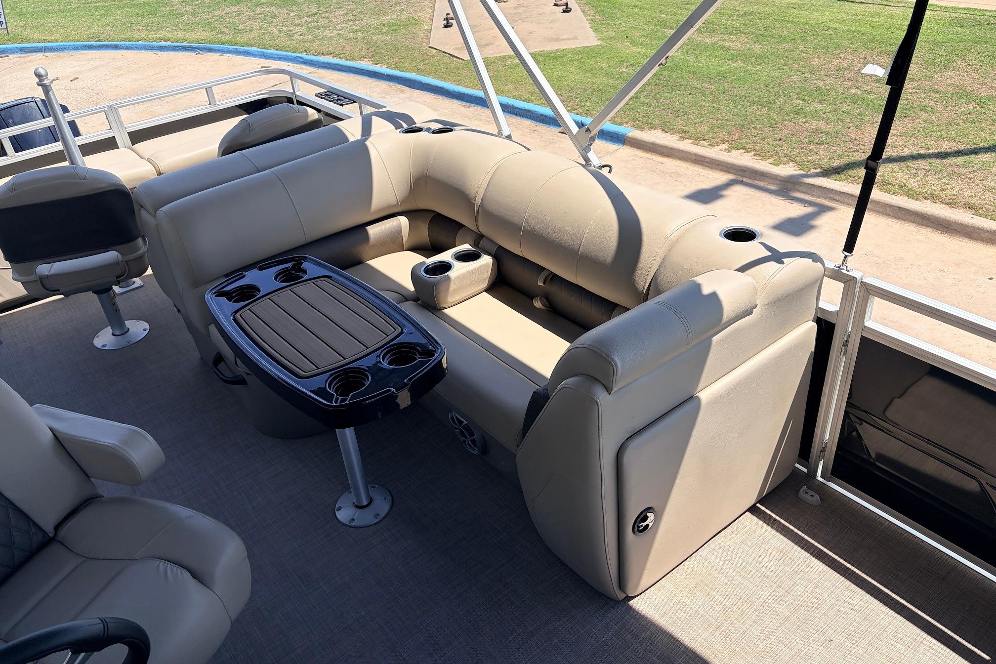 2024 Sun Tracker SportFish 22 XP3 pontoon boat with beige seating and table.