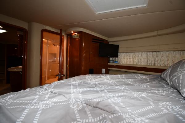 Interior cabin of 2003 Sea Ray 460 Sundancer yacht with bed and TV.