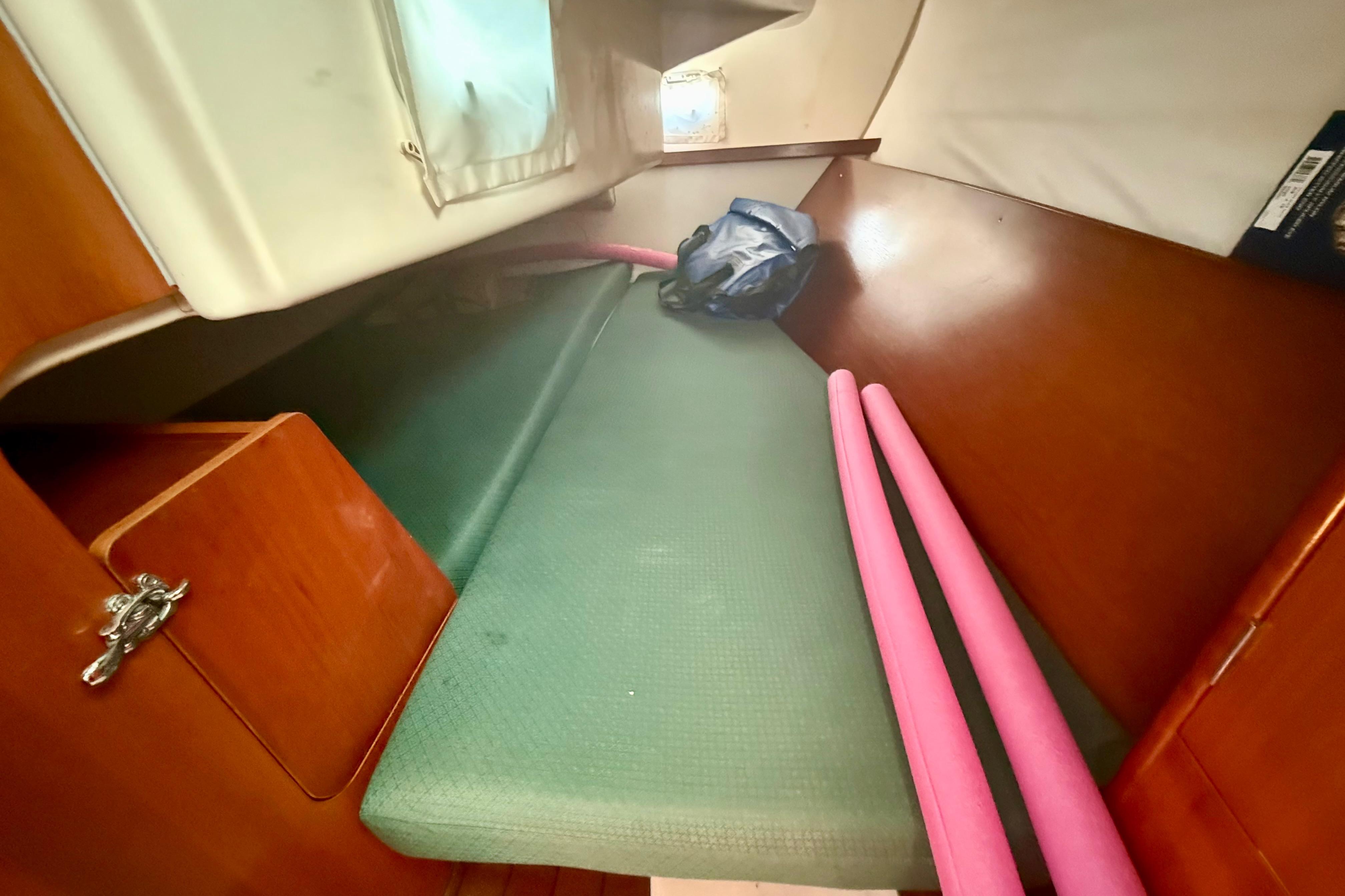 Interior cabin of 2002 Beneteau Oceanis Clipper 311 sailboat with green cushion and storage.