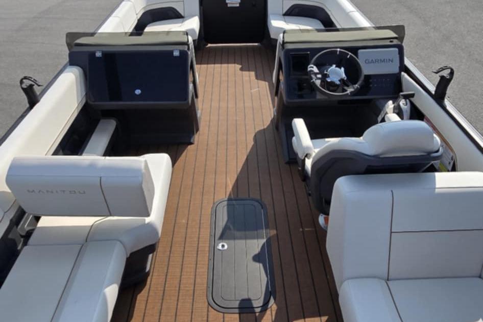 2025 Manitou Explore boat interior with modern seating and Garmin navigation system.