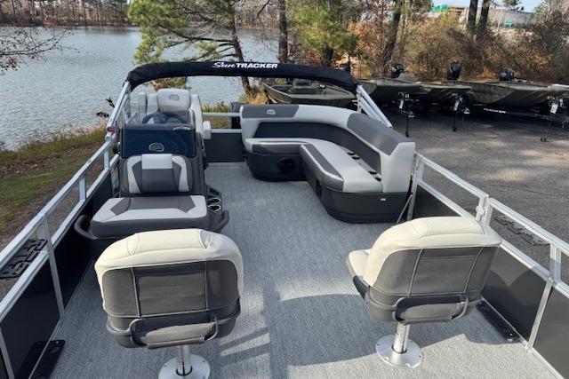 2026 Sun Tracker Bass Buggy 16 XL Select pontoon boat with spacious seating on a serene lake.