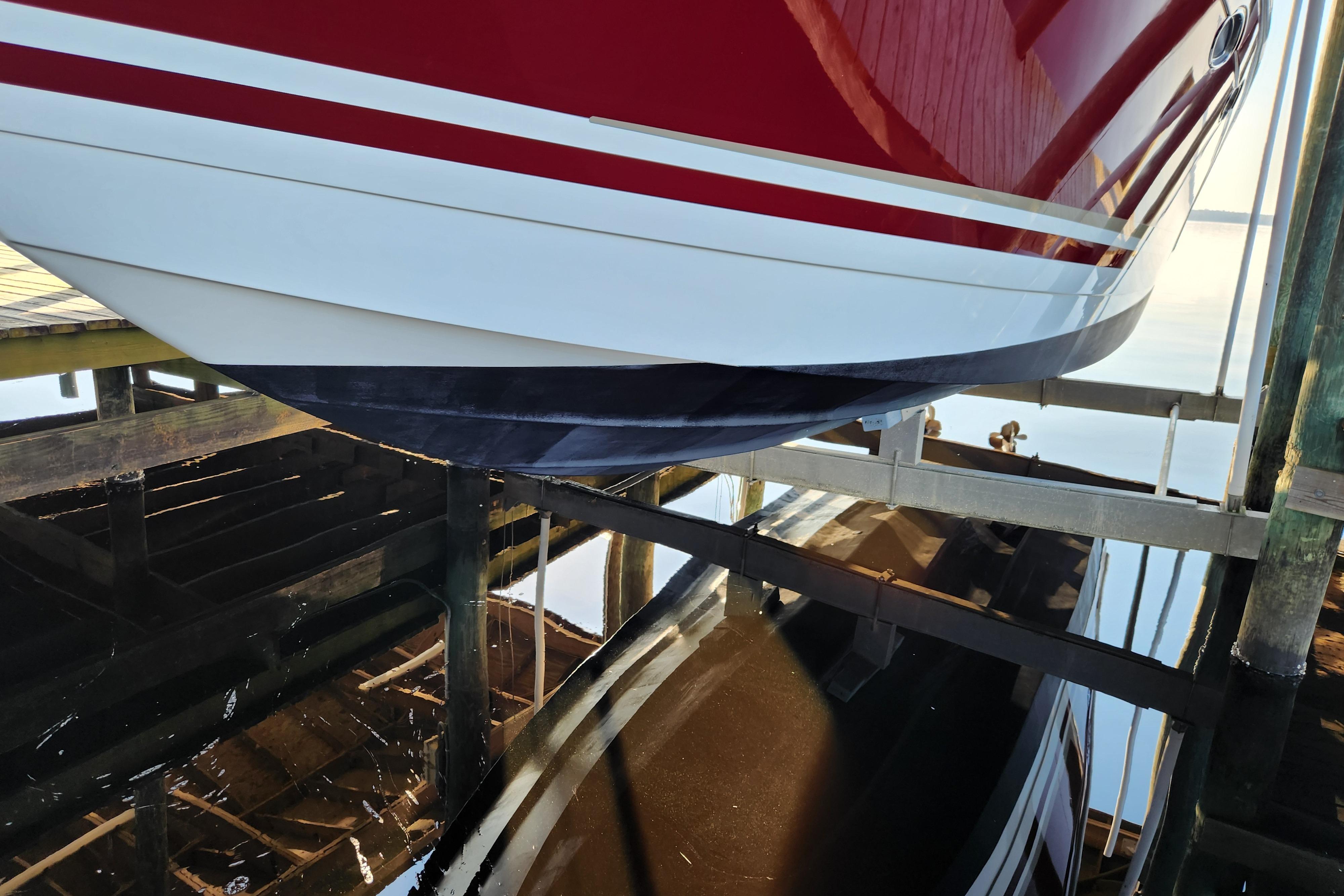 2015 Formula 34 Performance Cruiser on a boat lift, reflecting in calm water.