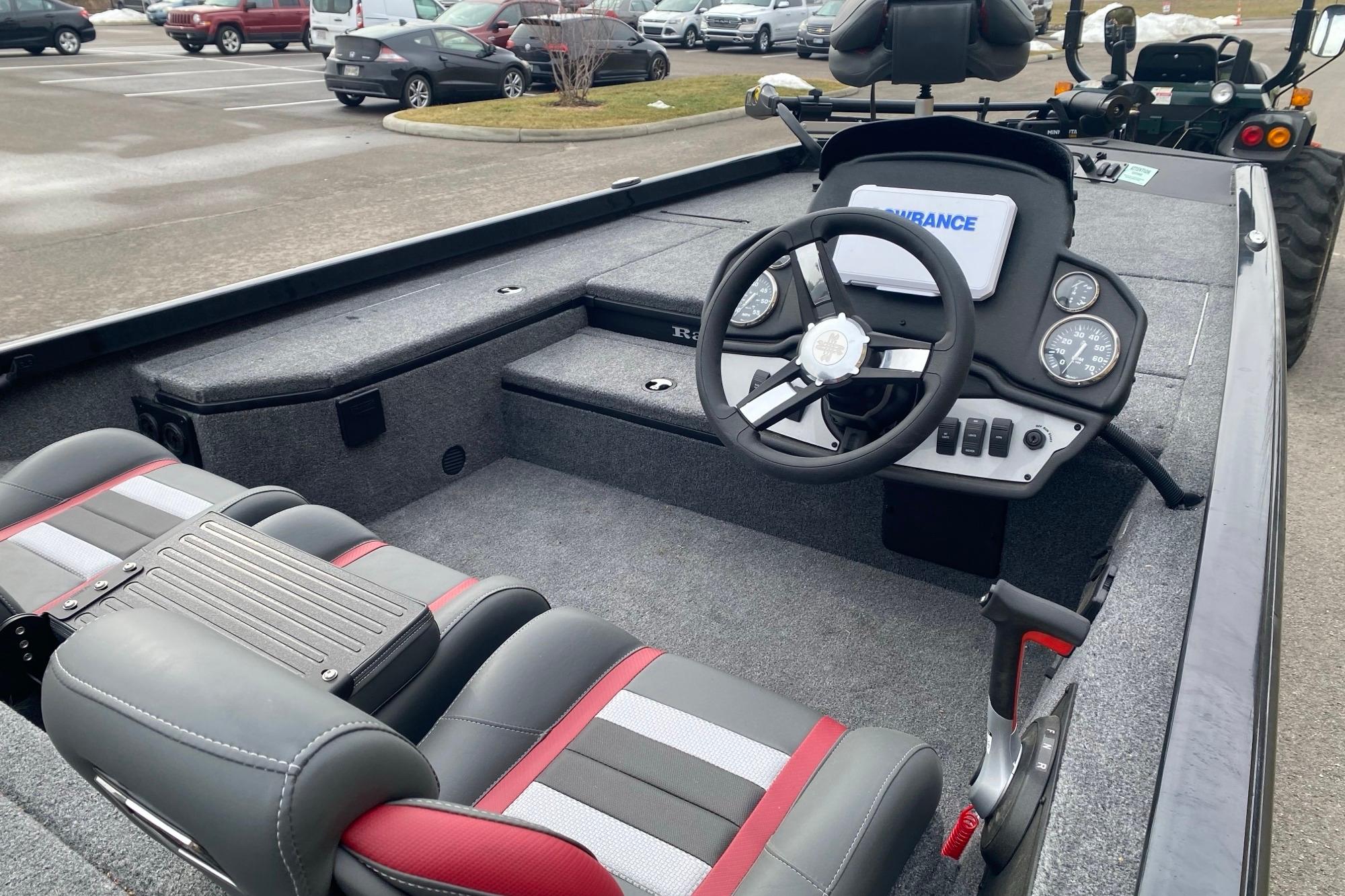 2025 Ranger RT178 boat interior with steering wheel and seating in a parking lot.