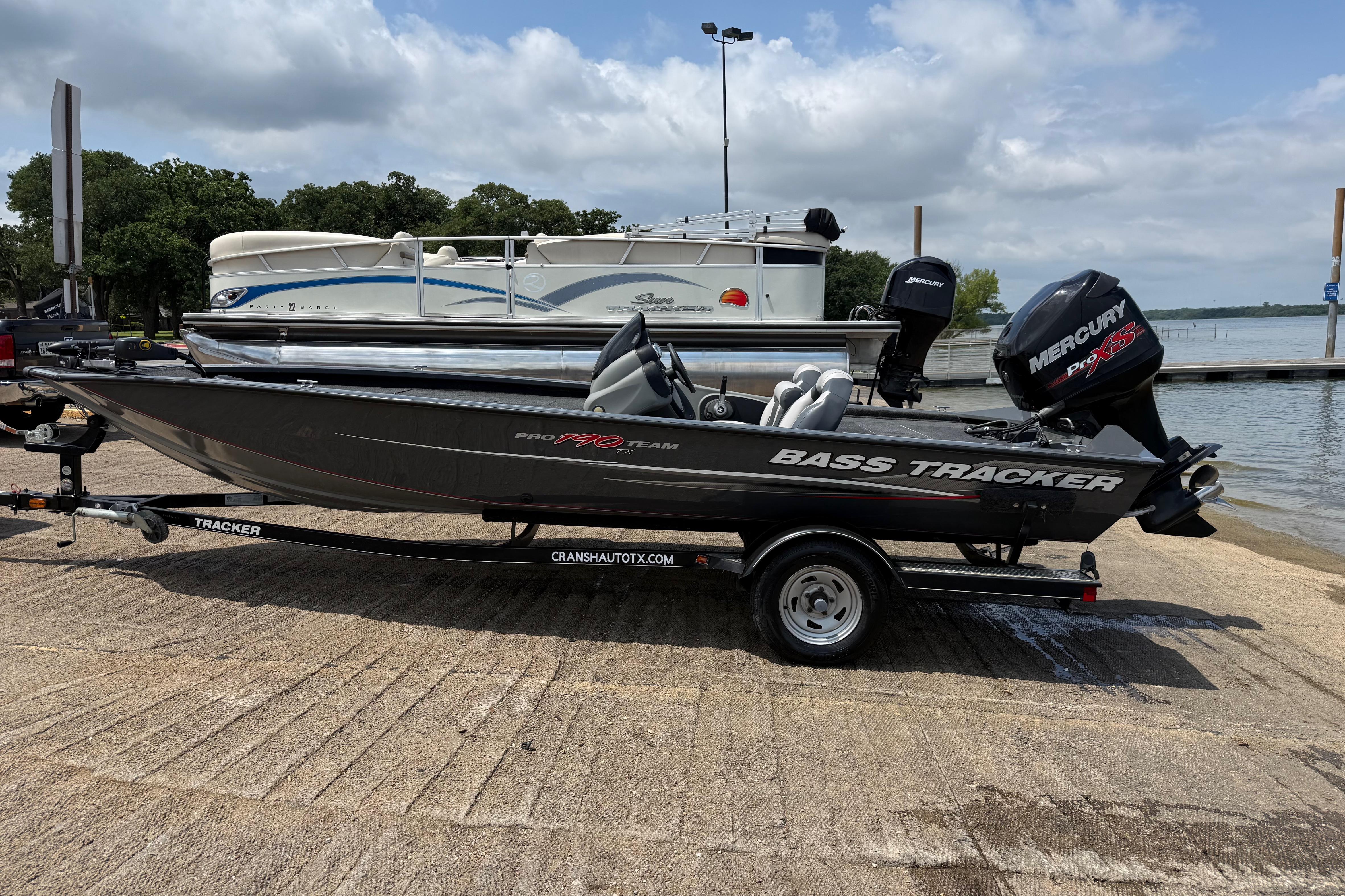 2015 Tracker Pro Team 190 TX bass boat on trailer by a lake.