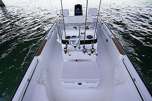 2026 Boston Whaler 170 Montauk boat interior with fishing rods and console on water.