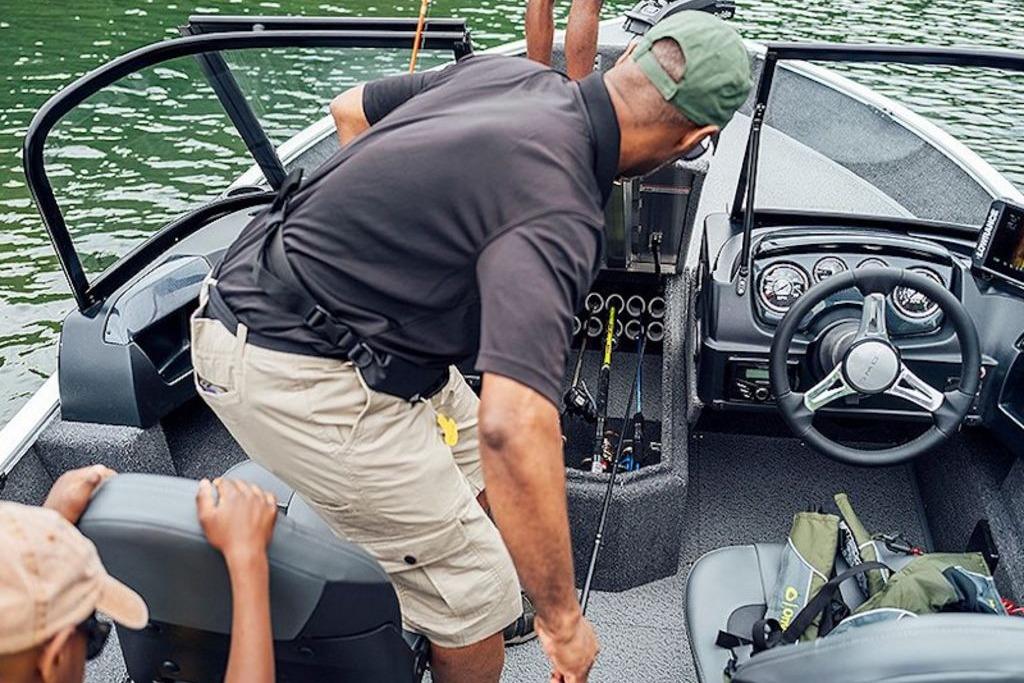 Man organizing fishing gear on 2026 Lowe Fishing Machine 175 boat.