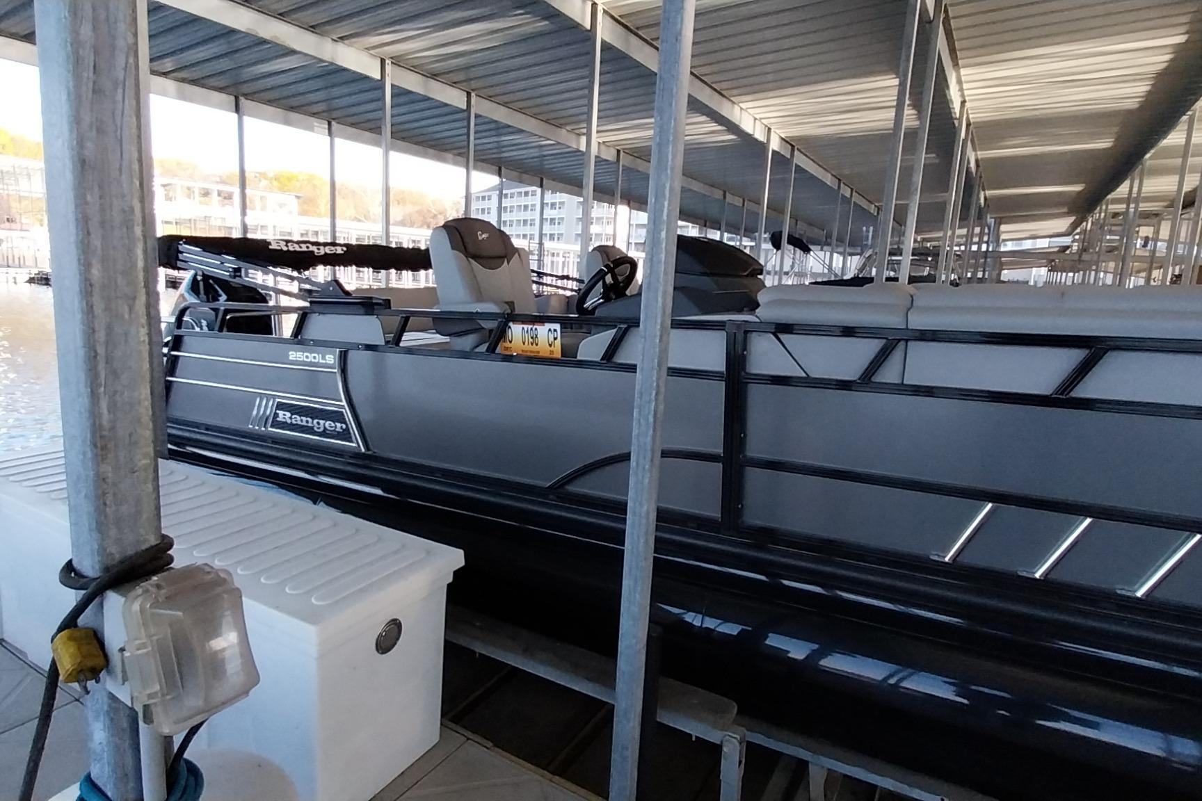 2023 Ranger 2500LS pontoon boat docked under covered marina.