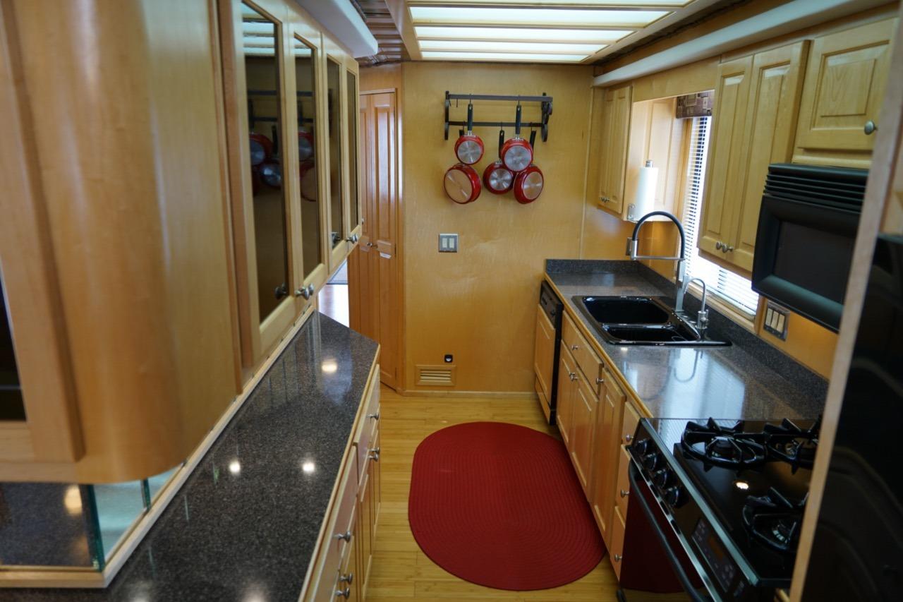 Modern kitchen in a 2000 Stardust Cruisers houseboat with wood cabinets and granite countertops.