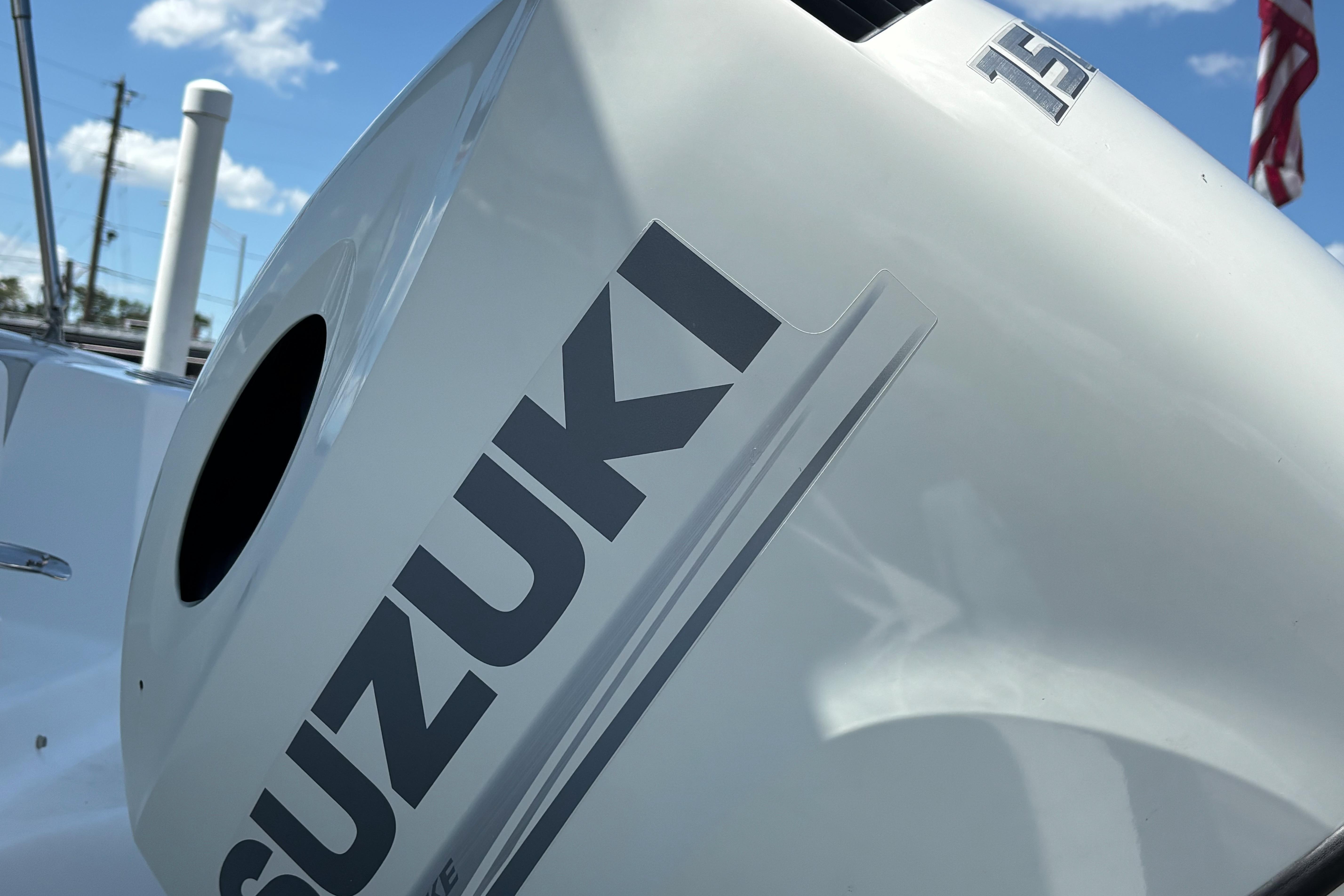 Suzuki outboard motor on 2019 Hurricane Sundeck Sport 218 OB boat, under clear sky.