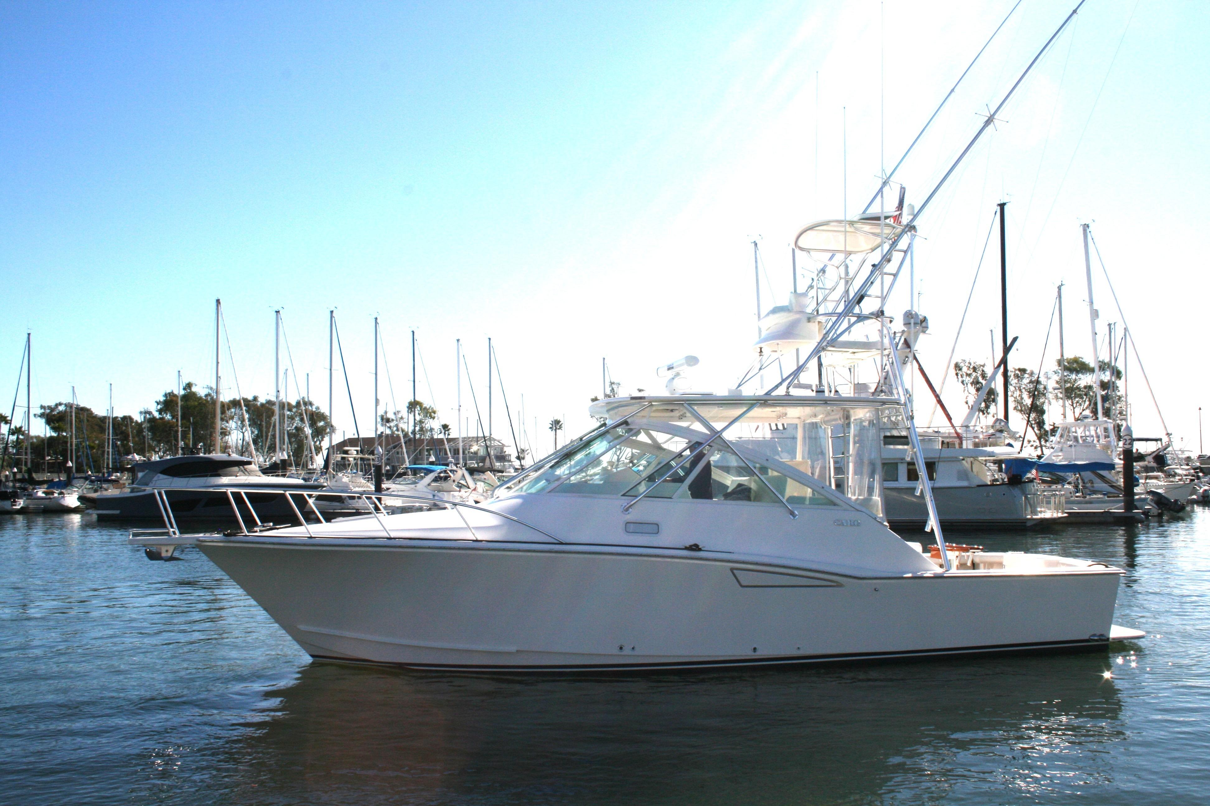 2005 Cabo 35 Express boat docked in a marina with clear blue skies.