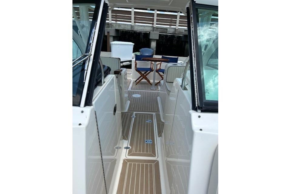 2013 Pursuit DC 265 Dual Console boat interior with seating and wooden flooring.