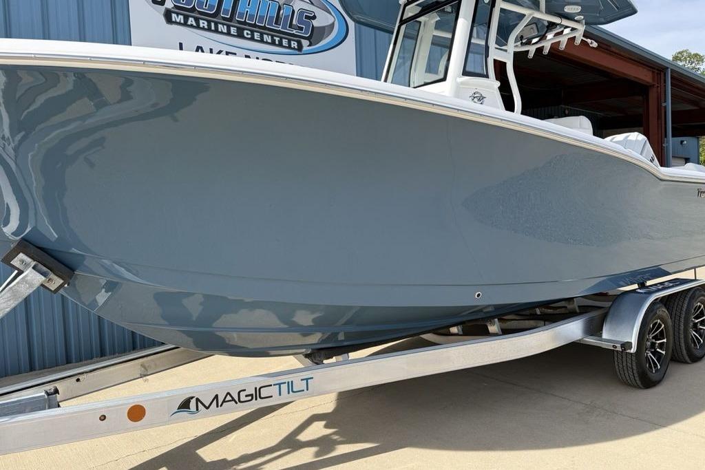 2026 Tidewater 232 LXF boat on Magic Tilt trailer at marine center.