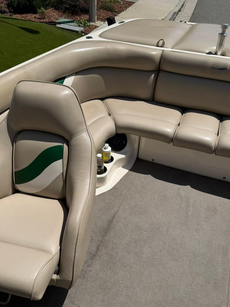 Interior of a Tigé 21V boat with beige leather seats and a green accent.