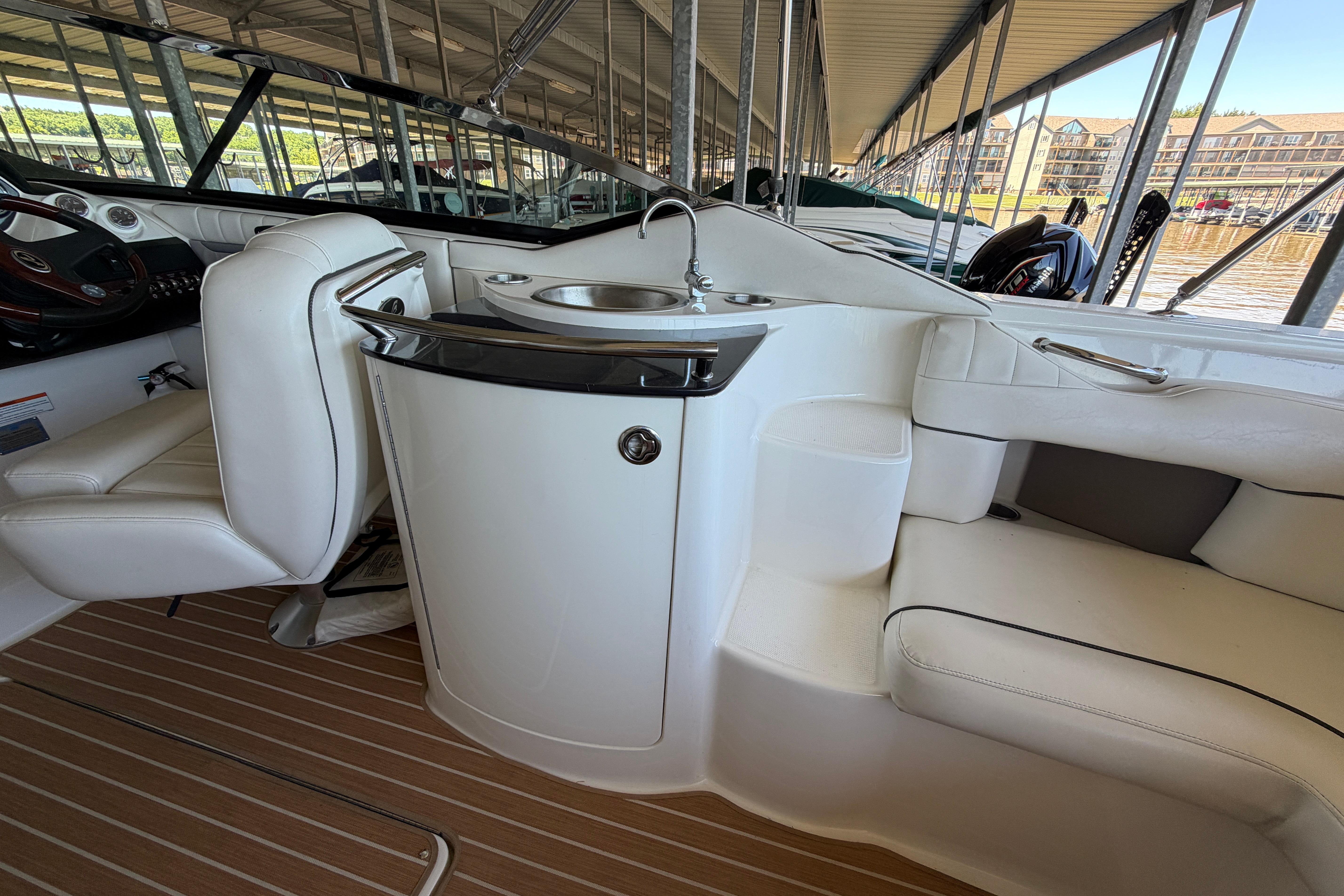 Interior of a 2007 Sea Ray 270 SLX boat with white seating and a compact sink.