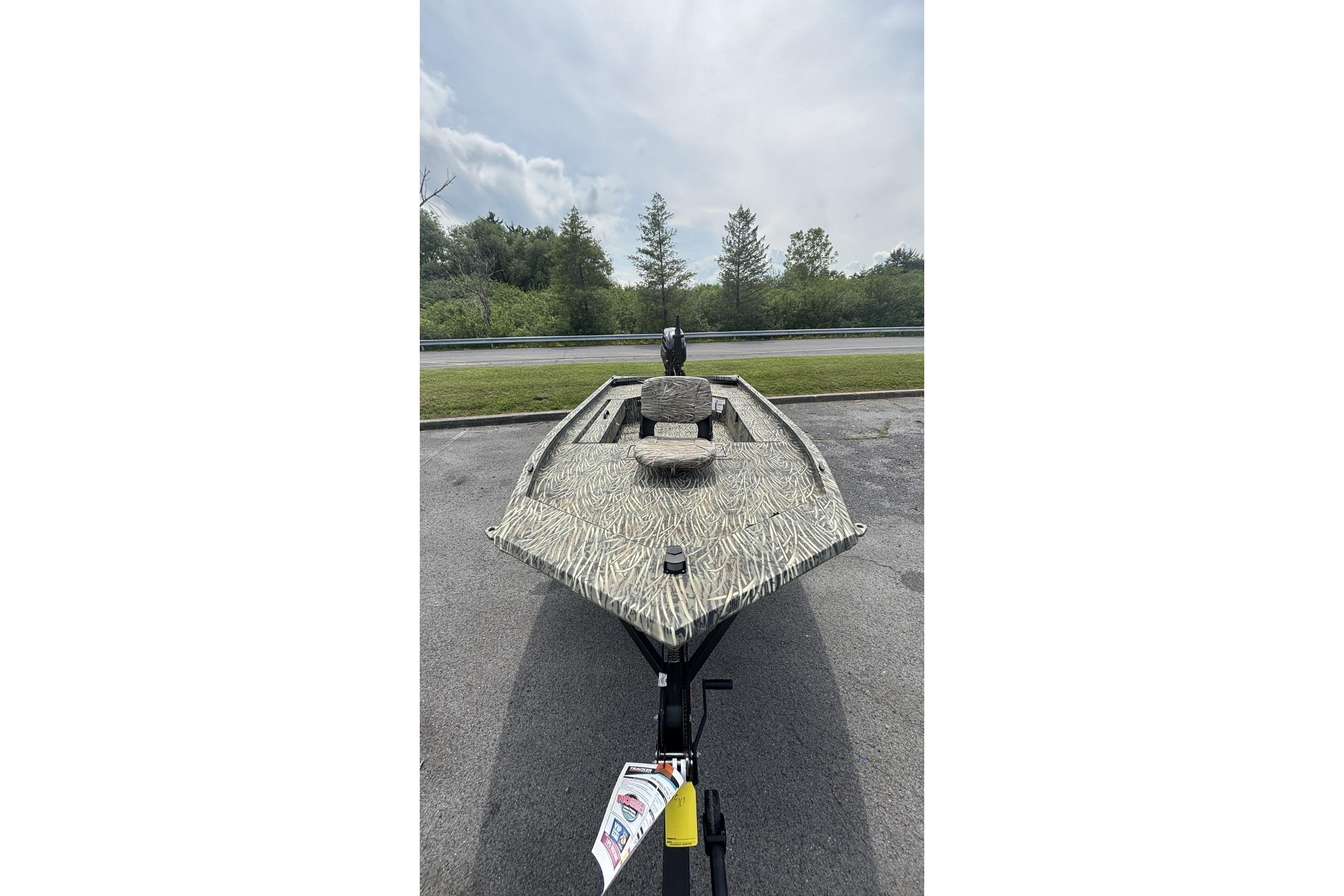 2026 Tracker Grizzly 1654 T Sportsman boat on trailer, camo design, outdoor setting.