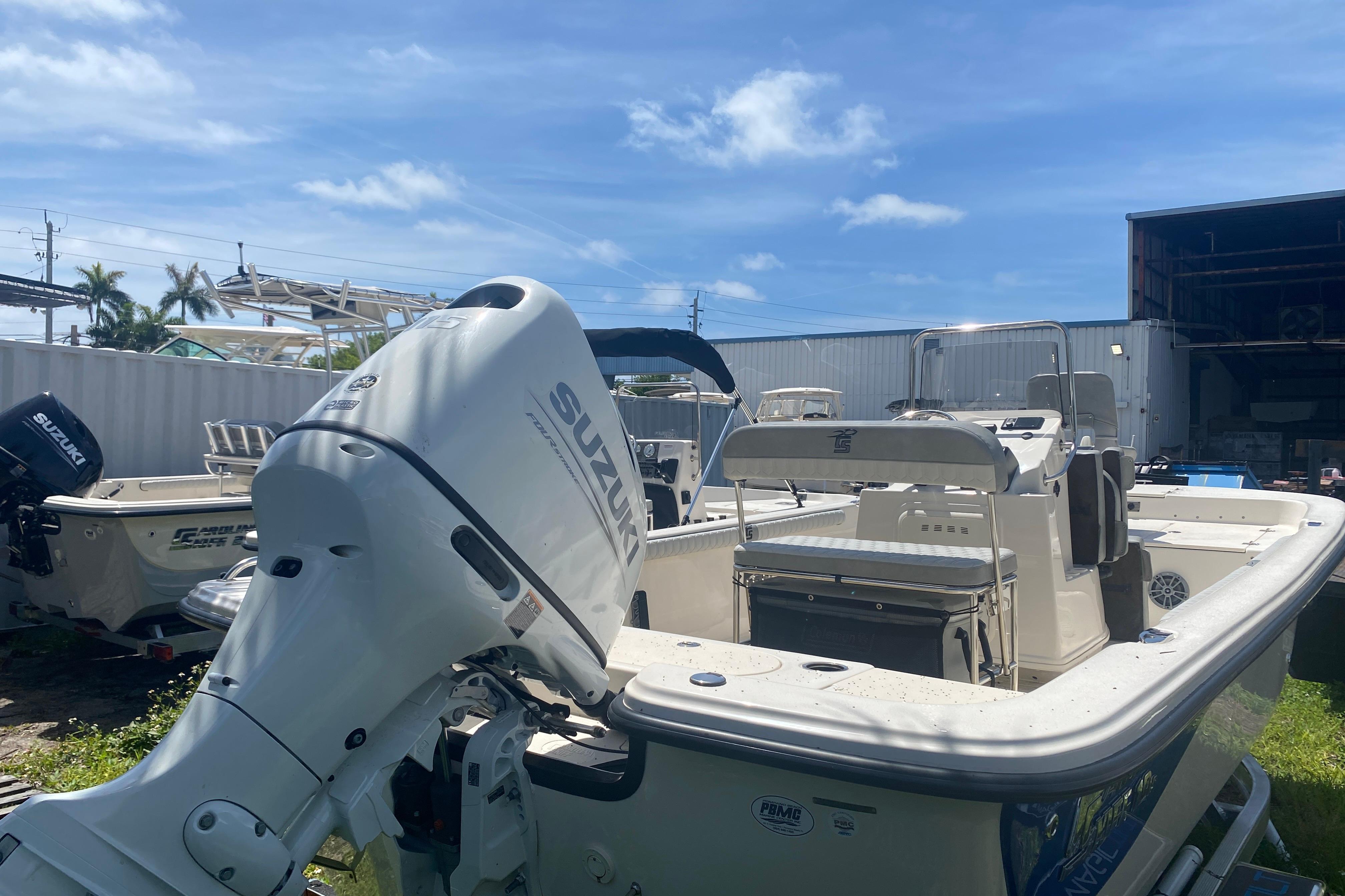 2026 Carolina Skiff 19 LS boat with Suzuki outboard motor in a sunny marina.