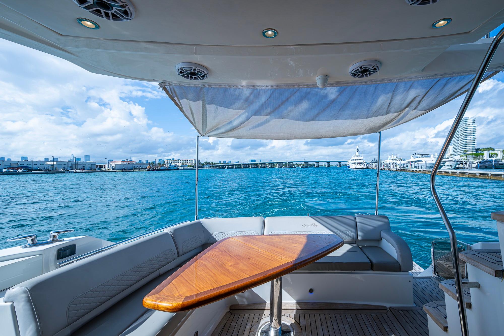 Luxurious 2018 Sea Ray L550 Fly yacht interior with ocean view and elegant seating area.