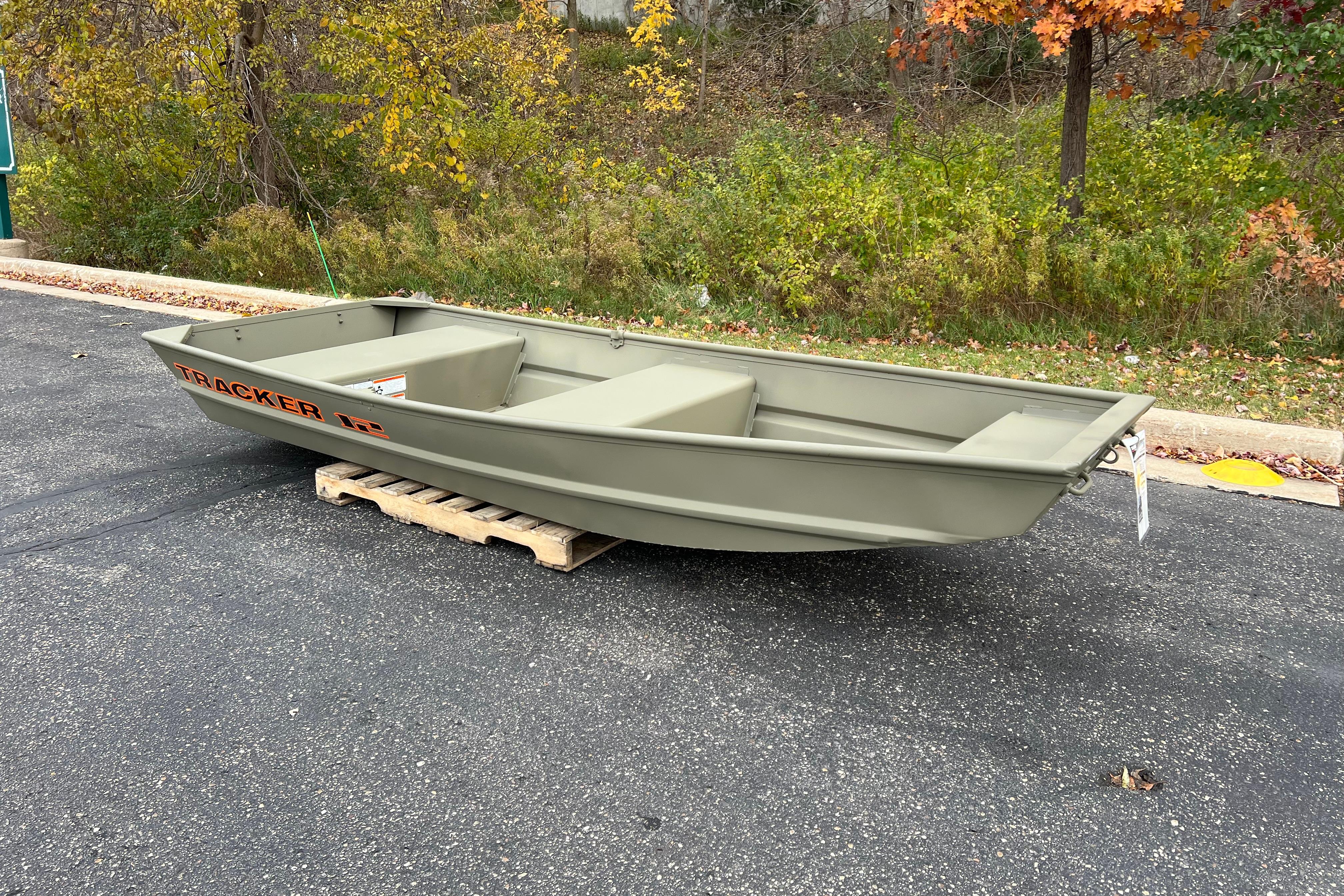 2026 Tracker Grizzly 12 Jon boat on a pallet, surrounded by autumn foliage.
