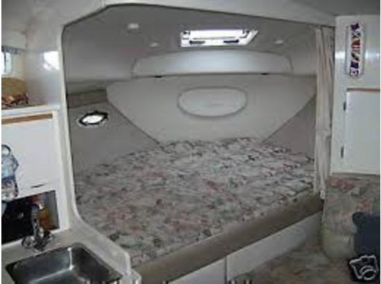 Interior cabin of a 2000 Bayliner 3055 Ciera Sunbridge boat with bed and sink.